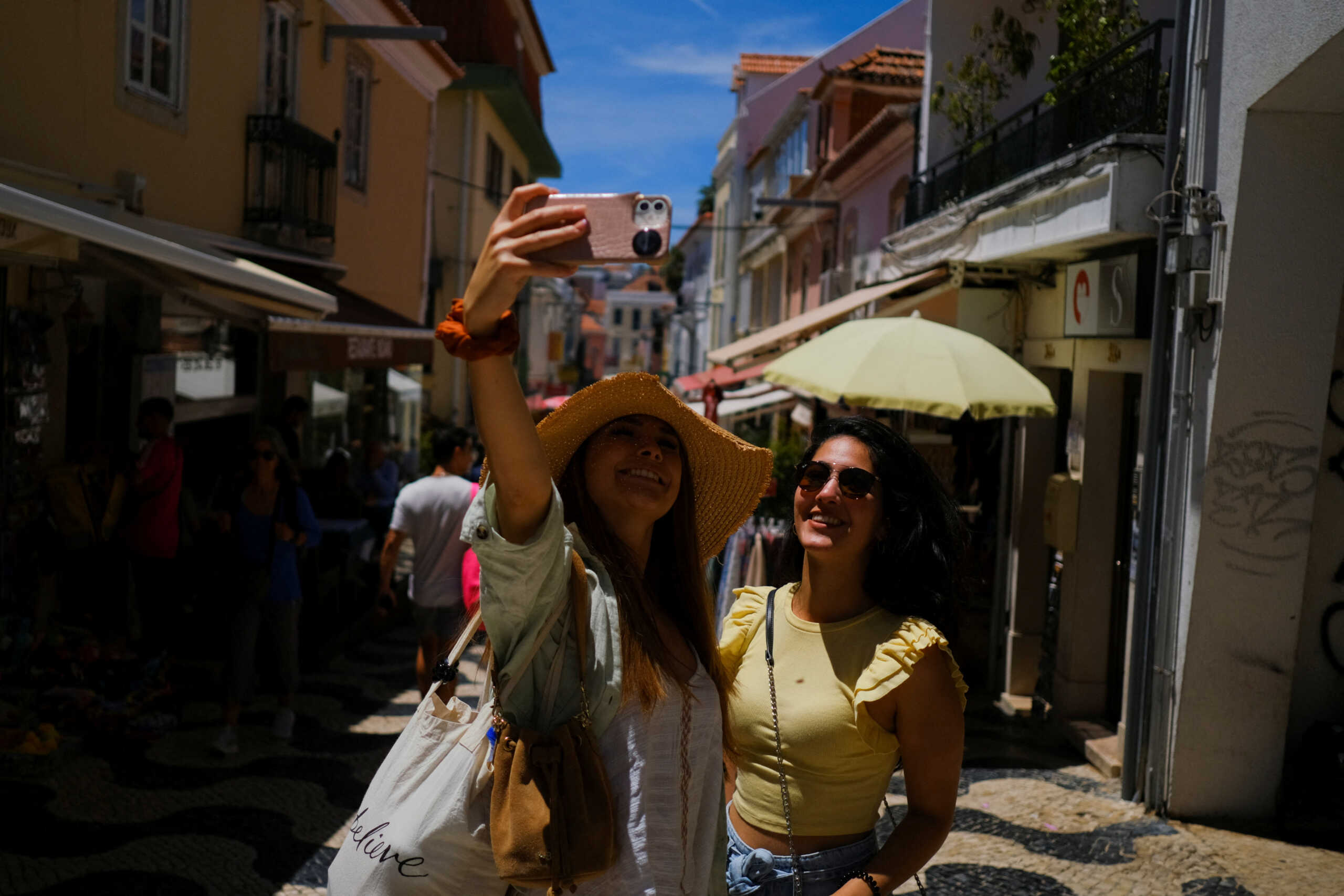Tourists take a picture on a street in Cascais, Portugal, June 6, 2022. Picture taken June 6, 2022. REUTERS