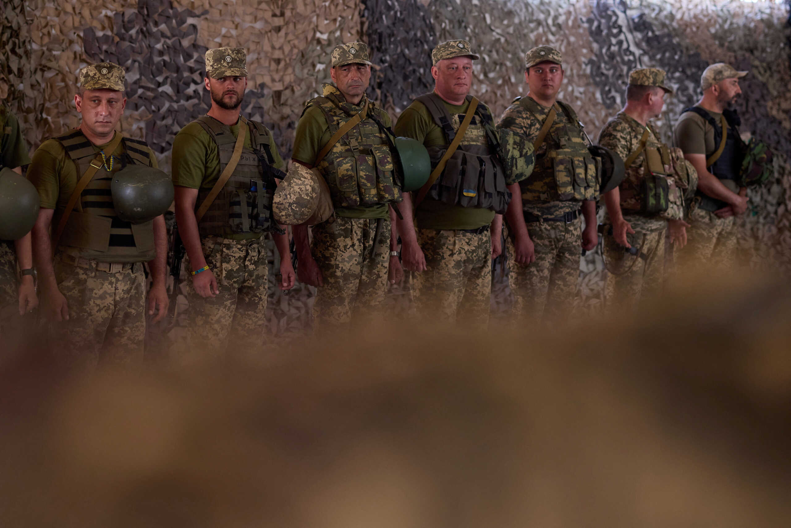 Ukrainian service members stand in line during a visit of President Volodymyr Zelenskiy to their position, as Russia's attack on Ukraine continues, in Dnipropetrovsk region, Ukraine July 8, 2022. Ukrainian Presidential Press Service