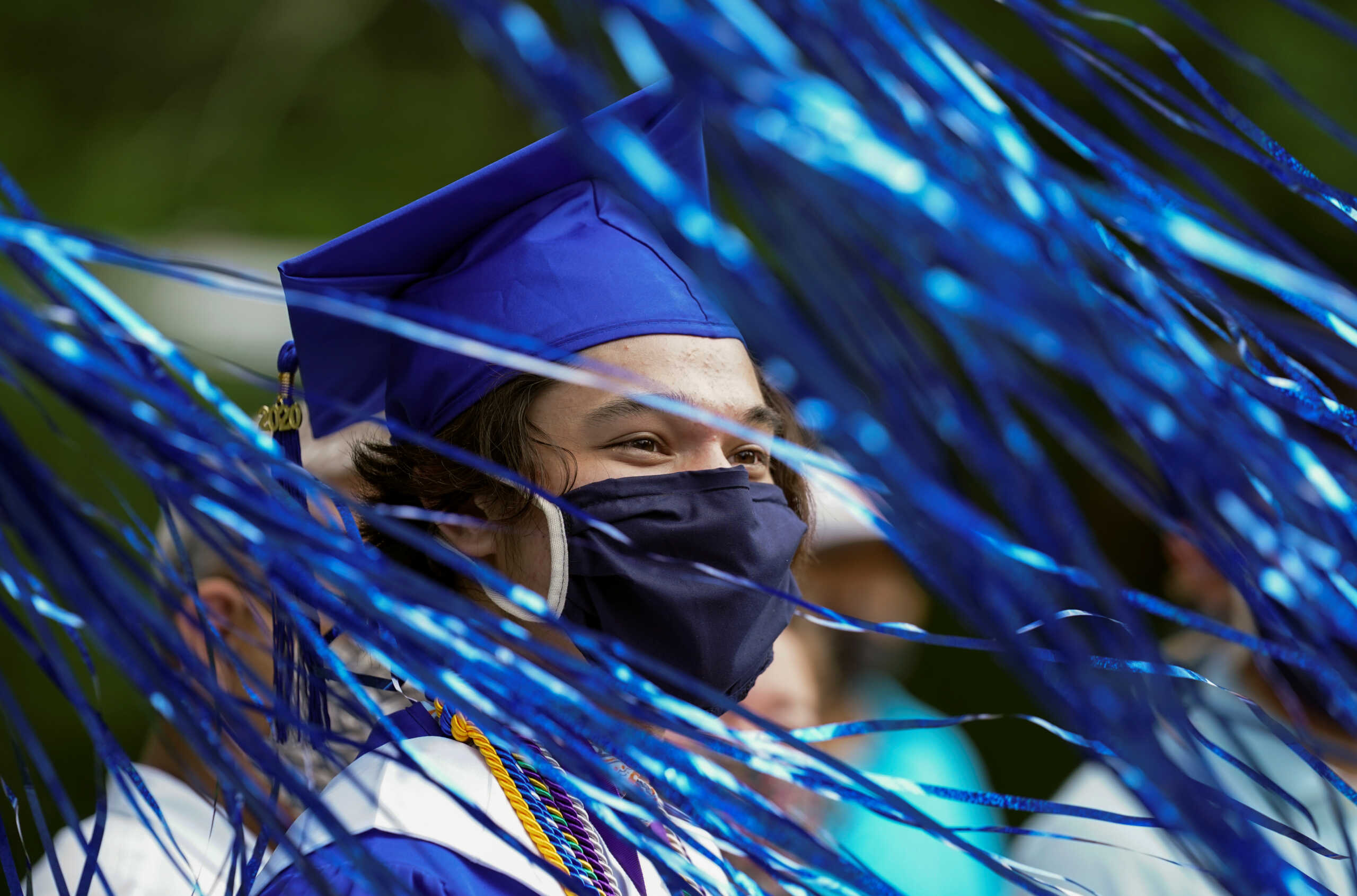 Streamers blow across the face of Bishop O'Connell High School graduate Rafael Ruiz during a front yard drive-in COVID-19 (coronavirus disease) honorary graduation ceremony in Falls Church, Virginia, U.S., June 13, 2020.  REUTERS
