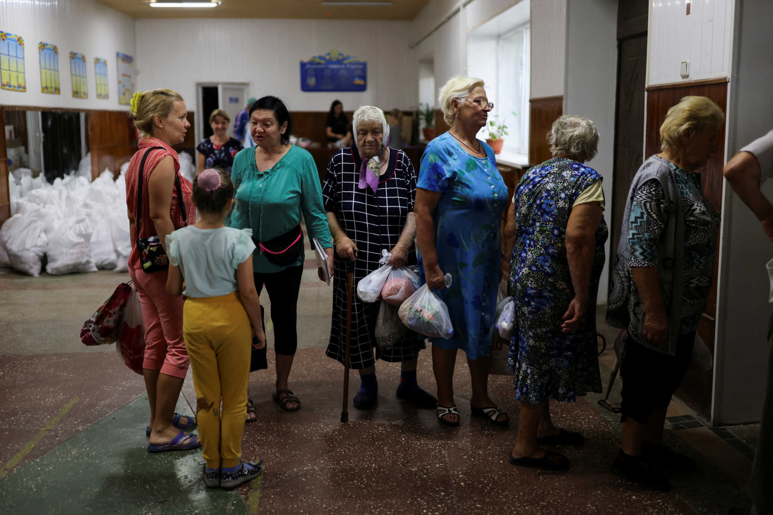 Residents pick up bags with food in the small village of Malaya Rohan, after military strikes, as Russia's invasion of Ukraine continues, in Kharkiv region Ukraine August 4, 2022. REUTERS