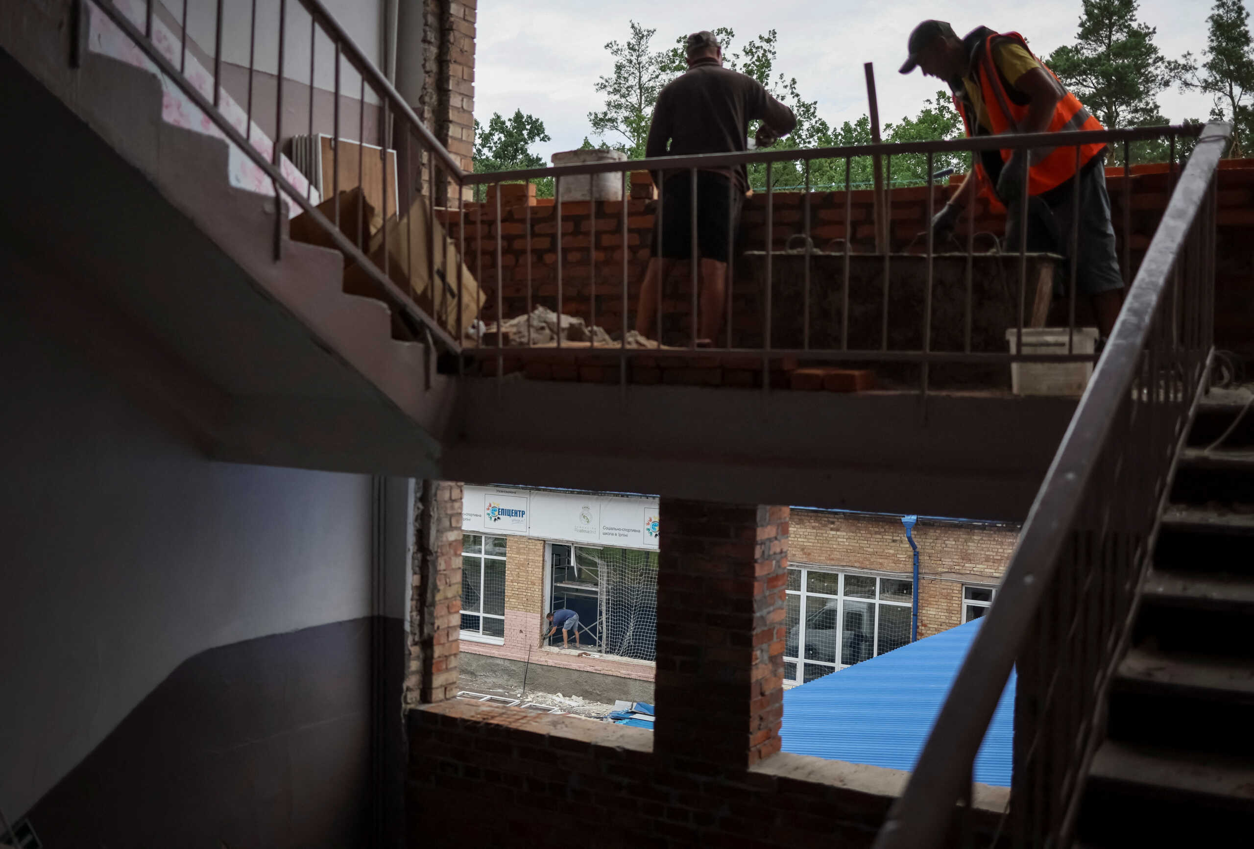 Workers replace windows blown out during a Russian artillery attack in a school in the town of Irpin, Kyiv region, Ukraine August 10, 2022.  REUTERS