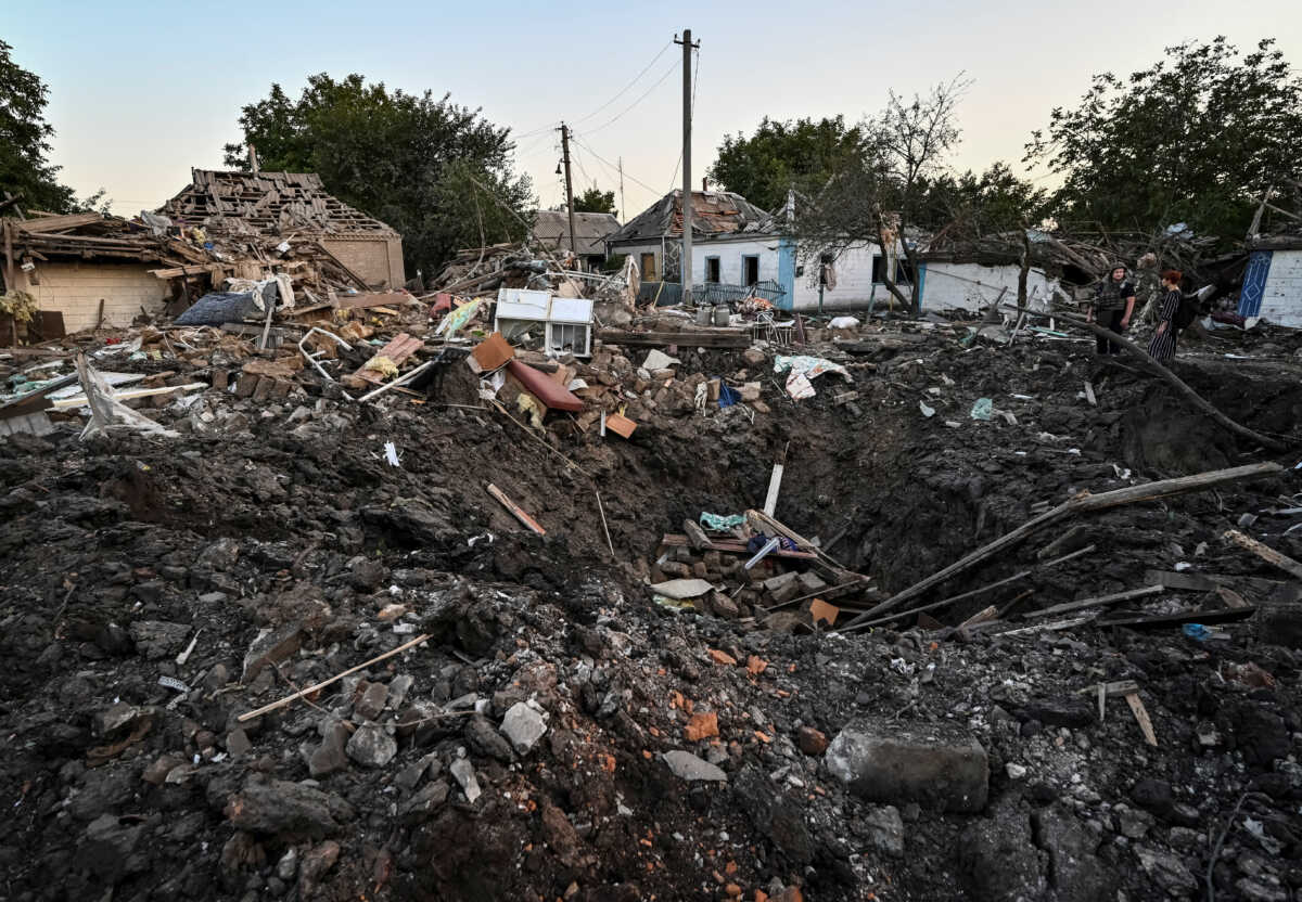 People stand next to a residential house destroyed by a Russian military strike, as Russia's attack on Ukraine continues, in Chaplyne, Dnipropetrovsk region, Ukraine August 24, 2022.  REUTERS