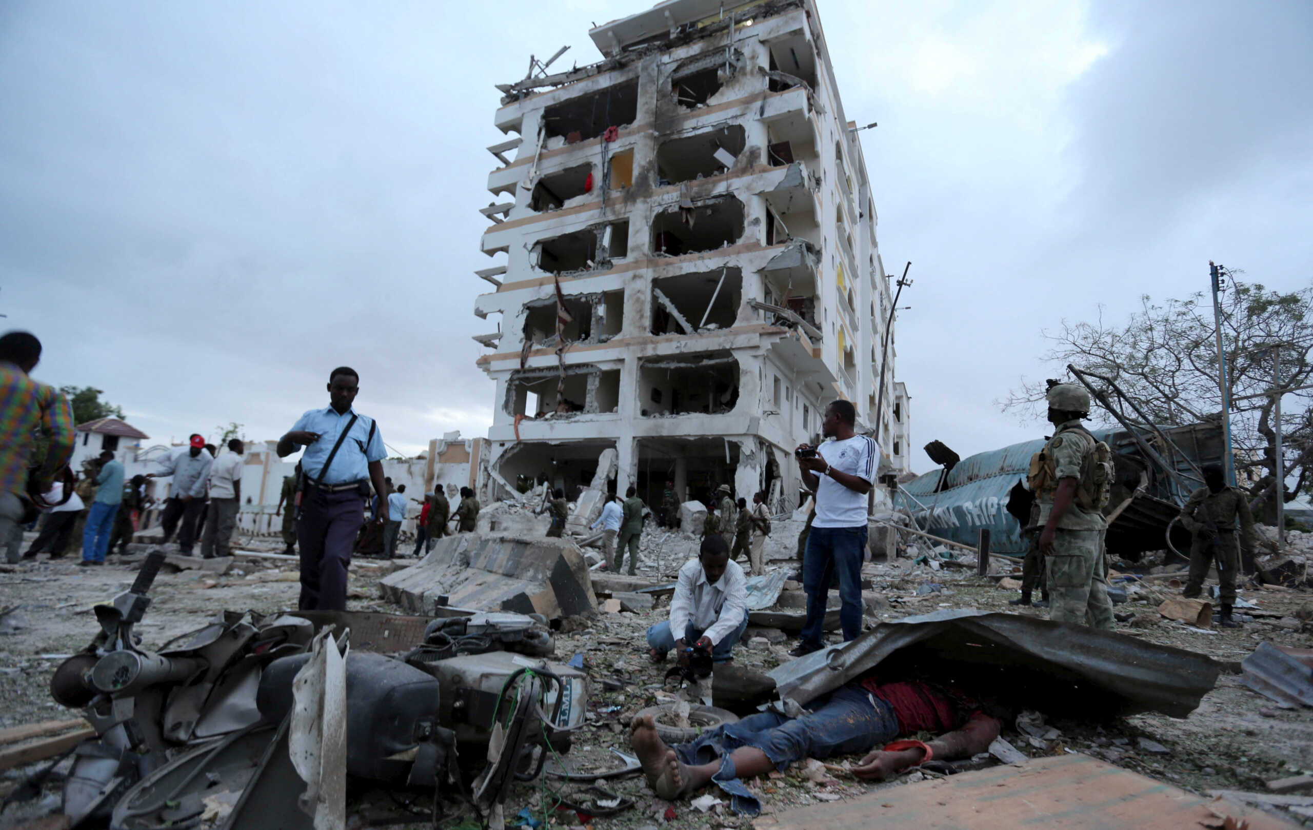 FILE PHOTO: ATTENTION EDITORS - VISUALS COVERAGE OF SCENES OF DEATH AND INJURY  Somali government soldiers and journalists stand outside the ruins of the Jazeera hotel after an attack in Somalia's capital Mogadishu, July 26, 2015. At least four people were killed on Sunday when Somalia's al Shabaab Islamist militant group drove a car packed with explosives at the gate of a hotel, police and the rebel group said. REUTERS