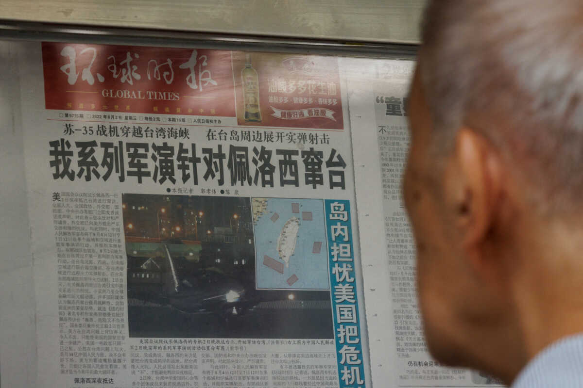 A man reads a Global Times article about military exercises by the Chinese People's Liberation Army (PLA) following U.S. House of Representatives Speaker Nancy Pelosi's Taiwan visit, at a newspaper stand in Beijing, China, August 4, 2022.   REUTERS