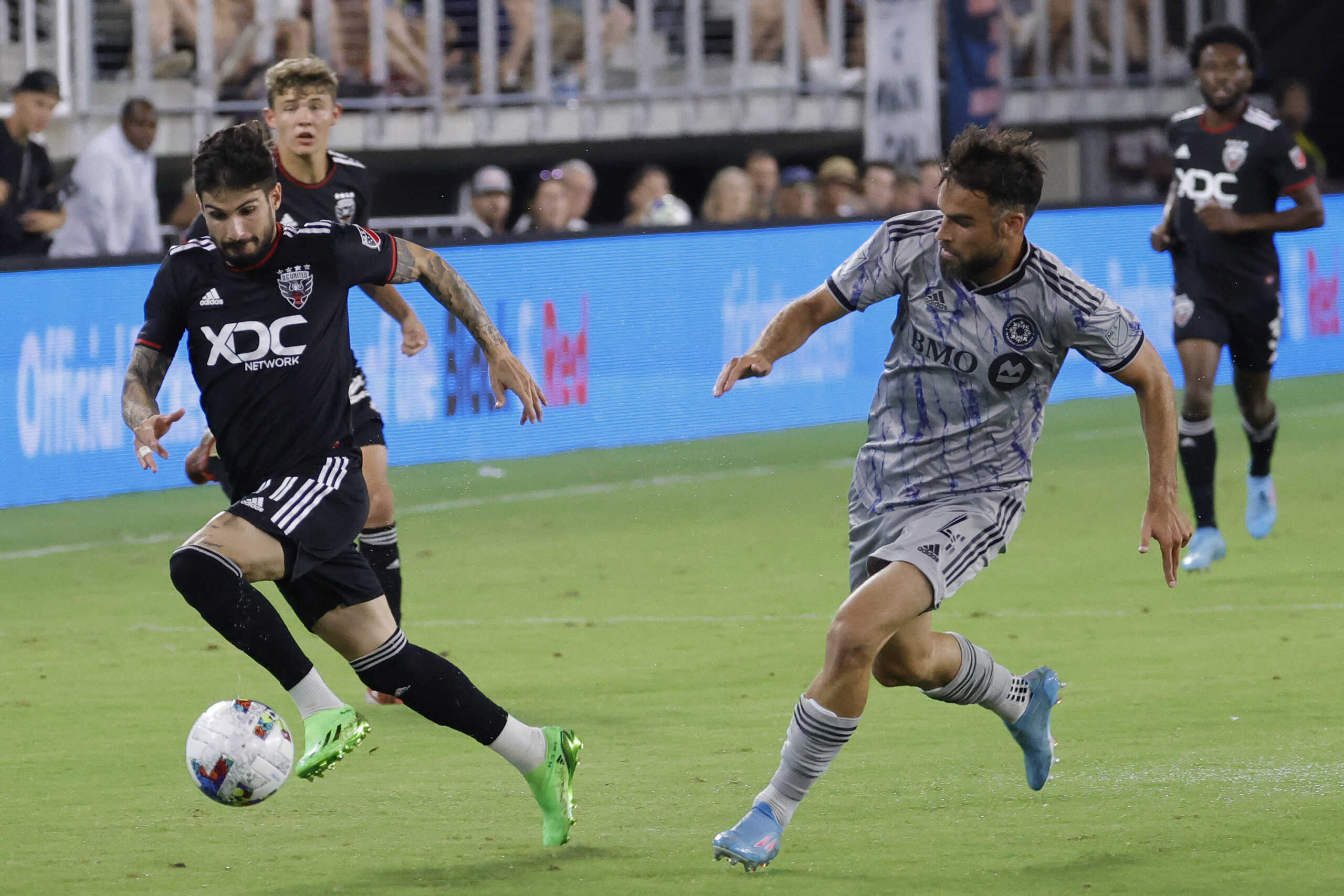 Jul 23, 2022; Washington, District of Columbia, USA; D.C. United forward Taxiarchis Fountas (11) dribbles the ball as CF Montral defender Rudy Camacho (4) defends in the second half at Audi Field. Mandatory Credit: Geoff Burke-USA TODAY Sports