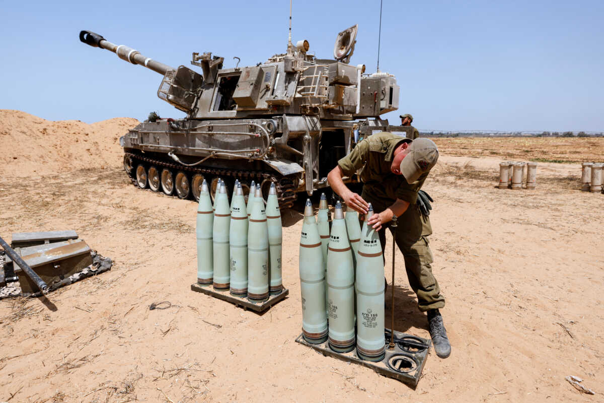An Israeli soldier checks ammunition next to a mobile artillery unit in a field on the Israeli side of the border with the Gaza Strip August 6, 2022. REUTERS
