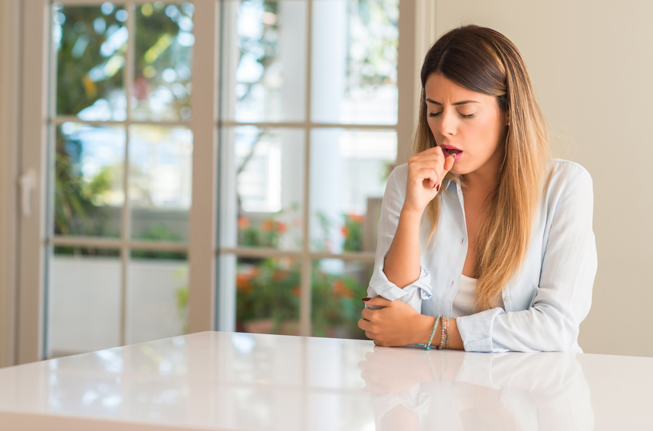 Young beautiful woman at home sick and coughing, suffering asthma or bronchitis, medicine concept