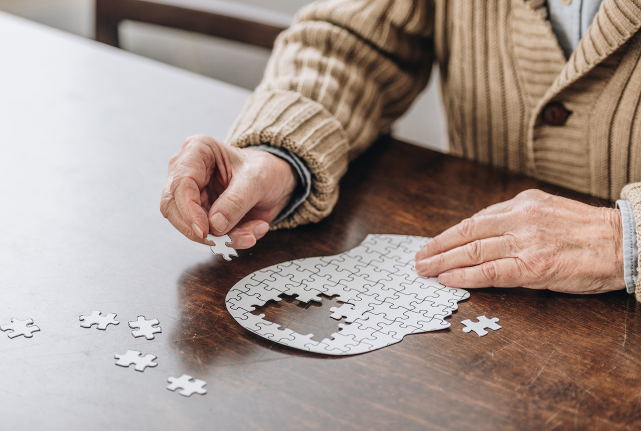 cropped view of senior man playing with puzzles