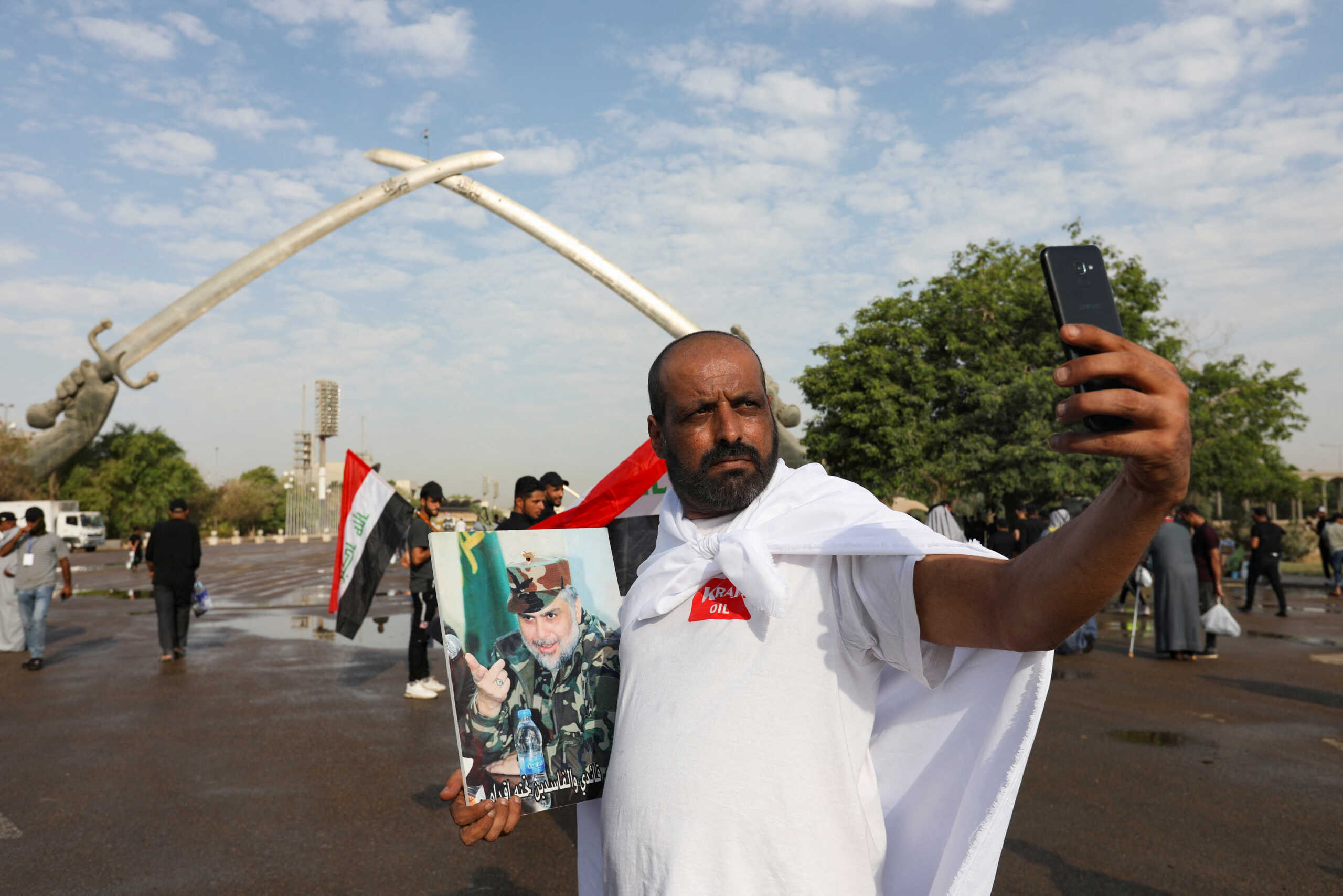 A man takes a photo as supporters of Iraqi populist leader Moqtada al-Sadr gather for mass Friday prayer at Grand Festivities Square within the Green Zone, in Baghdad, Iraq August 5, 2022. REUTERS