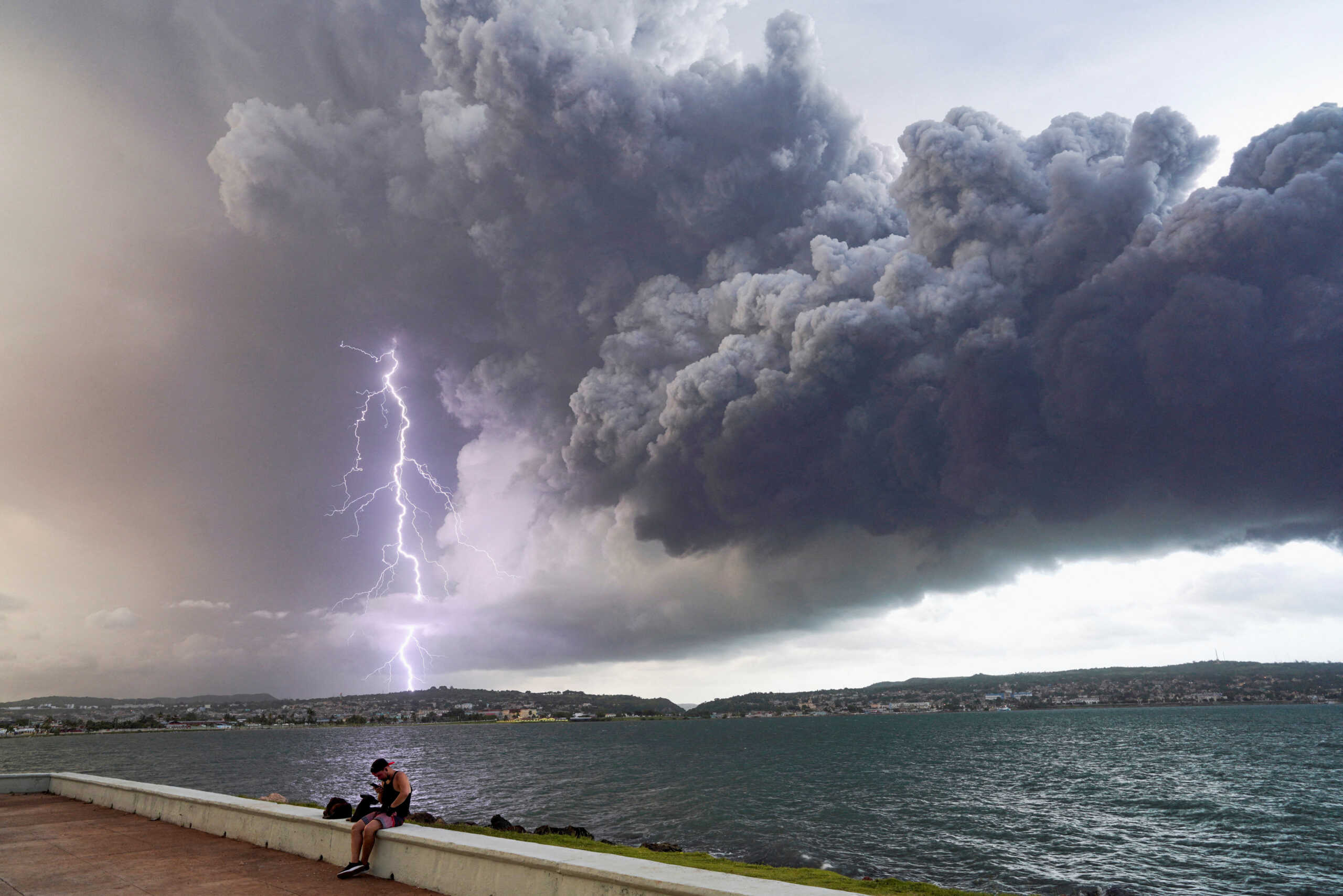 A lightning strikes through smoke from fuel storage tanks that exploded near Cuba's supertanker port in Matanzas, Cuba, August 8, 2022. REUTERS