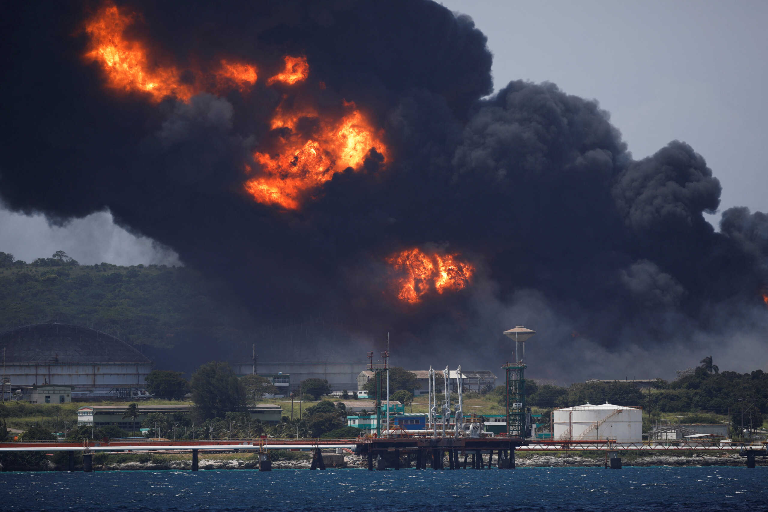Fire is seen over fuel storage tanks that exploded near Cuba's supertanker port in Matanzas, Cuba, August 6, 2022. REUTERS