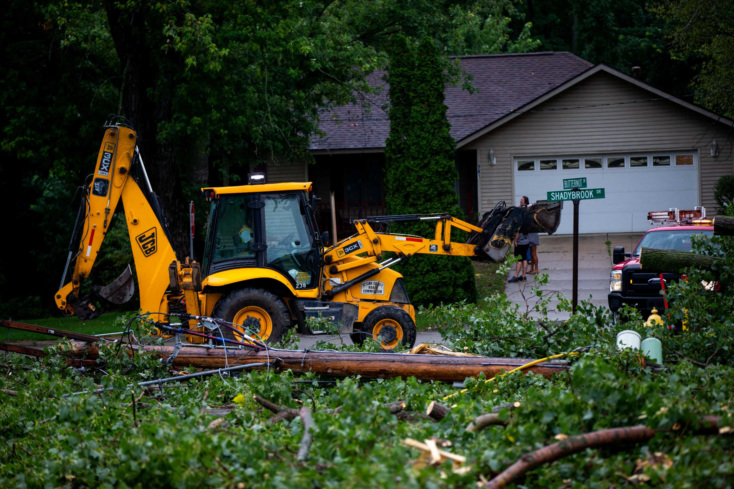 Fallen tree limbs are cleared after thunderstorms and high winds downed power lines and closed roads in Holland, Michigan, U.S. August 29, 2022.  Cody Scanlan