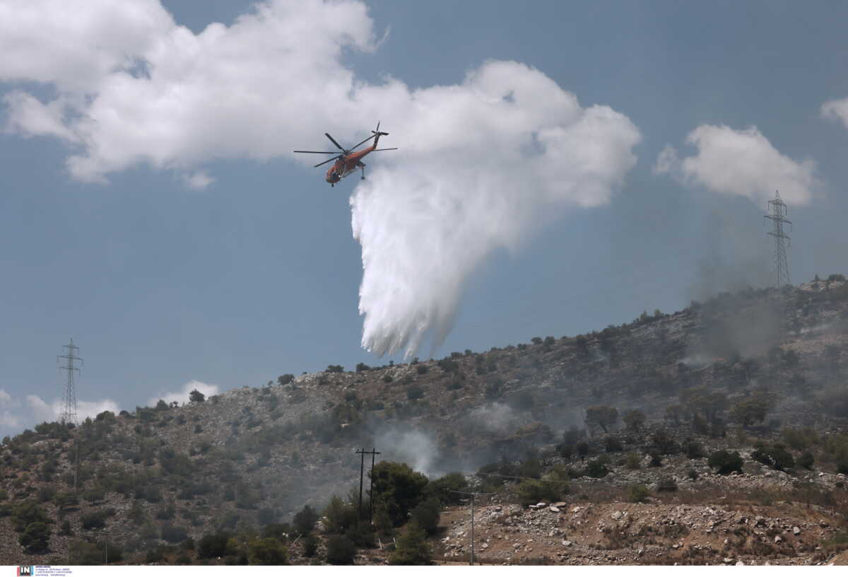 Φωτιά στη Νέα Πέραμο: Βελτιωμένη η εικόνα – Συνεχείς αναζωπυρώσεις, αναμένεται ενίσχυση των ανέμων