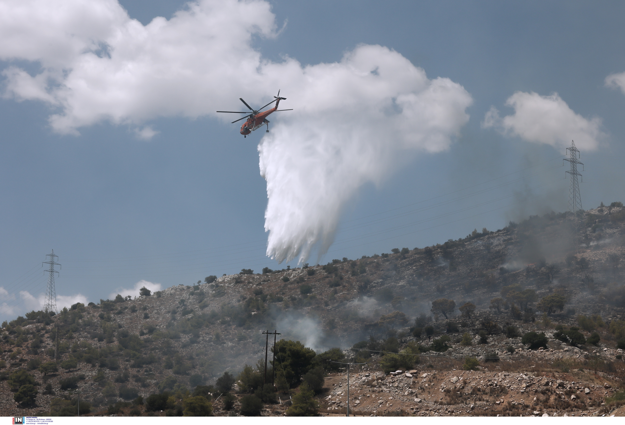 Φωτιά στη Νέα Πέραμο: Βελτιωμένη η εικόνα – Συνεχείς αναζωπυρώσεις, αναμένεται ενίσχυση των ανέμων