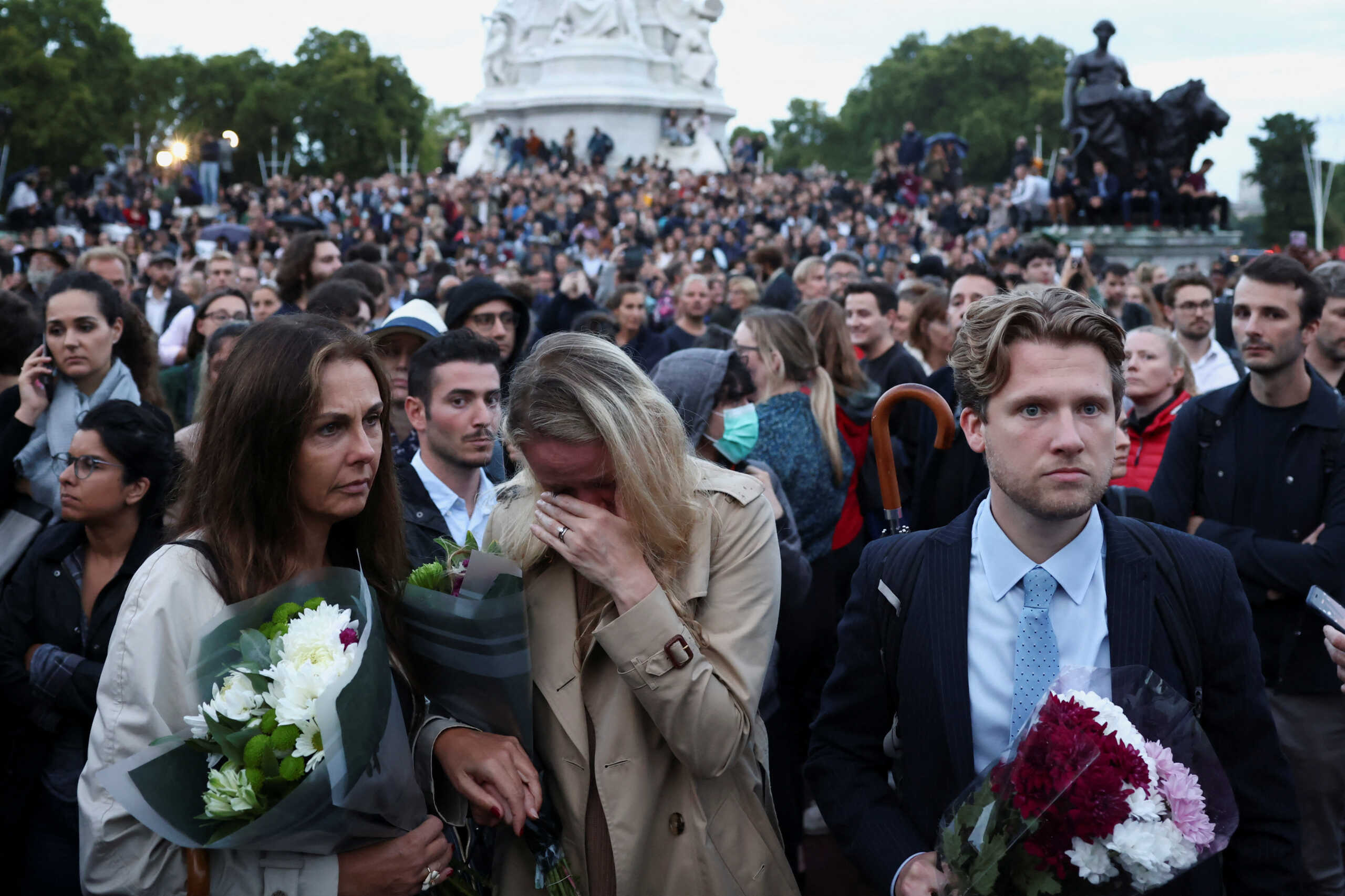 People react outside the Buckingham Palace, after Queen Elizabeth, Britain's longest-reigning monarch and the nation's figurehead for seven decades, died aged 96, according to Buckingham Palace, in London, Britain September 8, 2022. REUTERS