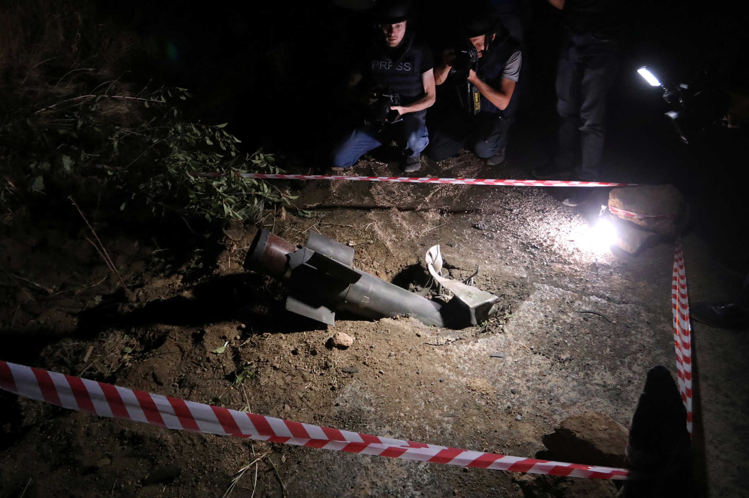 Journalists film the remains of a rocket shell following border clashes with Azerbaijan, in the town of Jermuk, Armenia September 15, 2022. Stepan Poghosyan