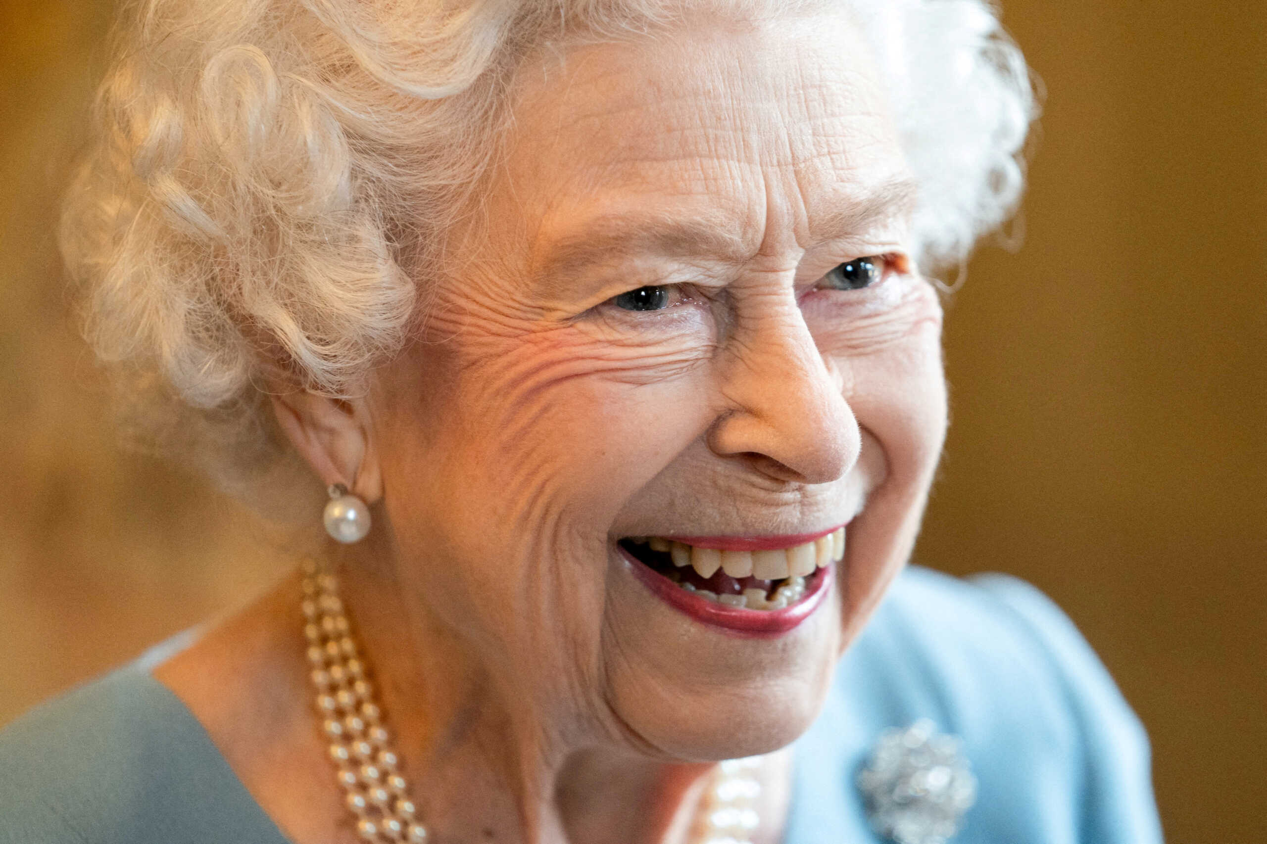 FILE PHOTO: Britain's Queen Elizabeth reacts as she attends a reception in the Ballroom of Sandringham House which is the Queen's Norfolk residence, with representatives from local community groups to celebrate the start of the Platinum Jubilee, in Sandringham, Britain, February 5, 2022. Joe Giddens