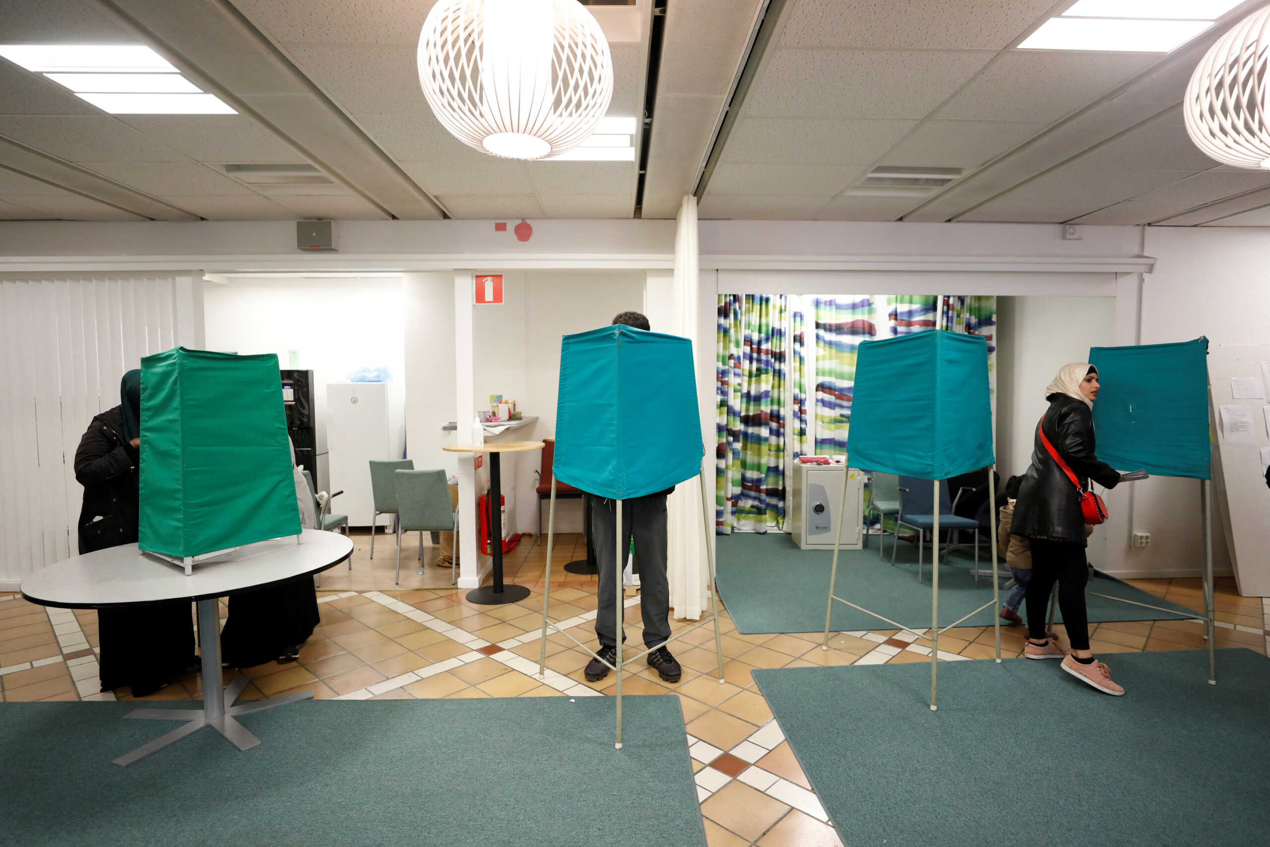 People cast their votes at a polling station for early voting in the suburb of Rinkeby, Stockholm, Sweden, September 10, 2022. TT News Agency