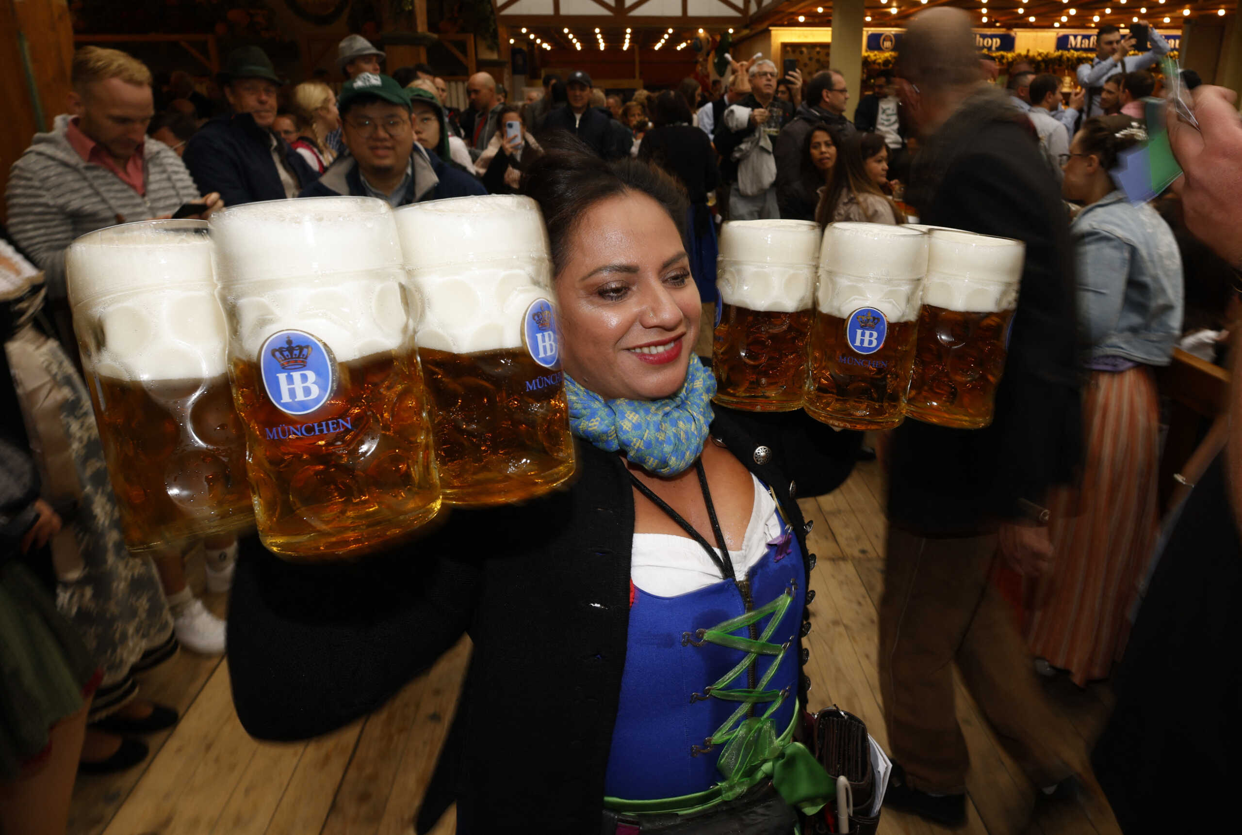 A waitress carries mugs of beer during the official opening the world's largest beer festival, the 187th Oktoberfest in Munich, Germany, September 17, 2022. REUTERS