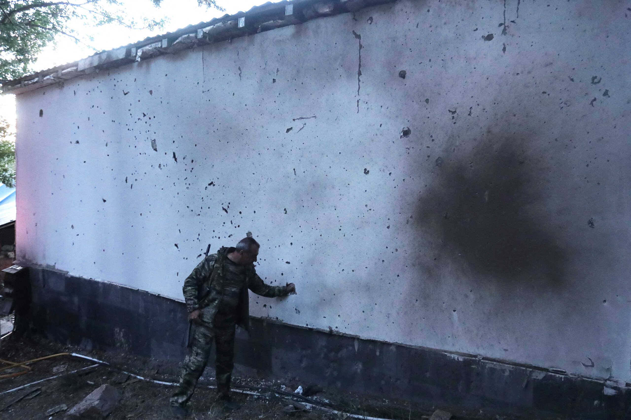 A man stands next to a building damaged by recent shelling during border clashes with Azerbaijan, in the town of Jermuk, Armenia September 15, 2022. Stepan Poghosyan