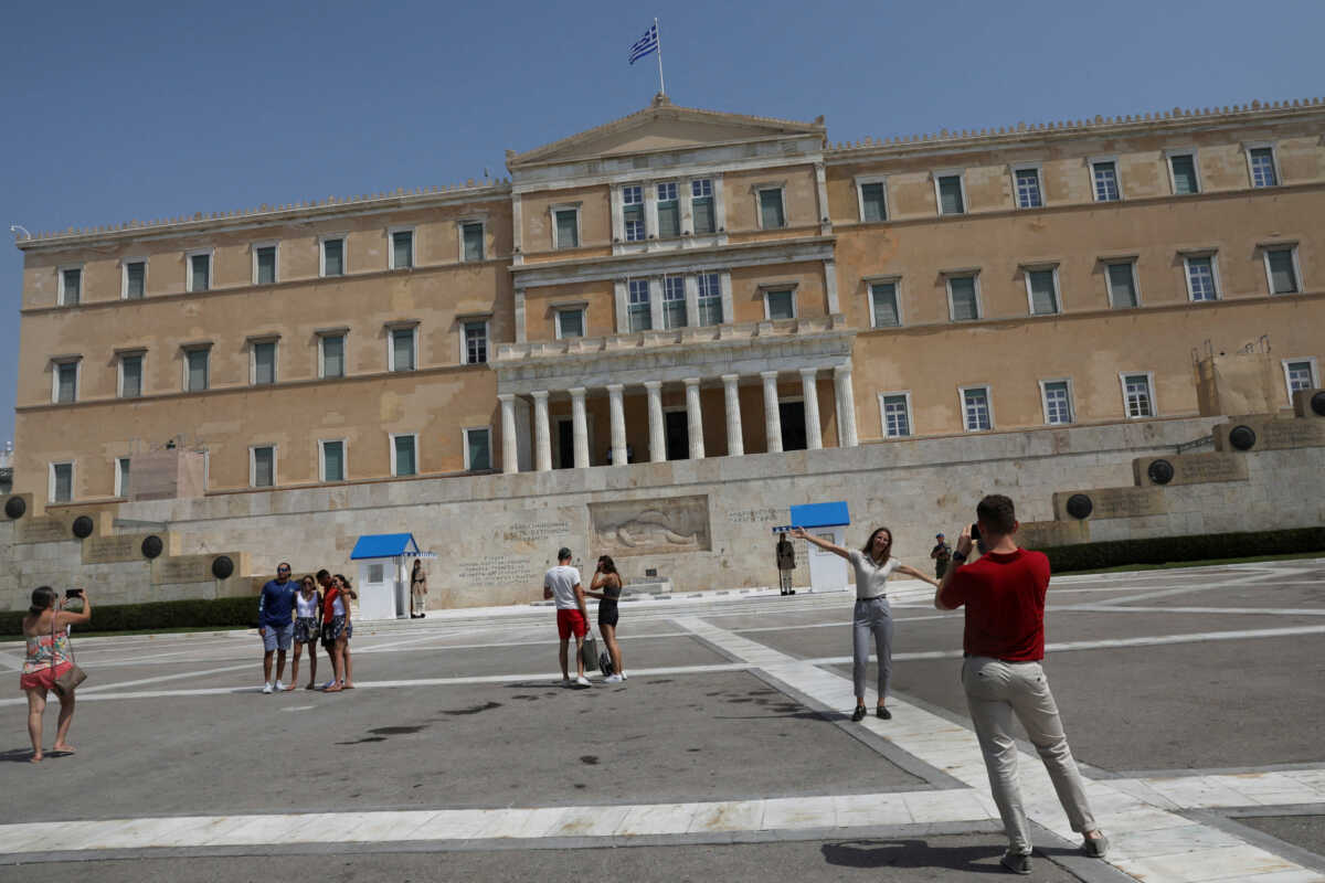 People take photos in front of the Greek parliament building on Syntagma square in Athens, Greece, August 20, 2022. REUTERS