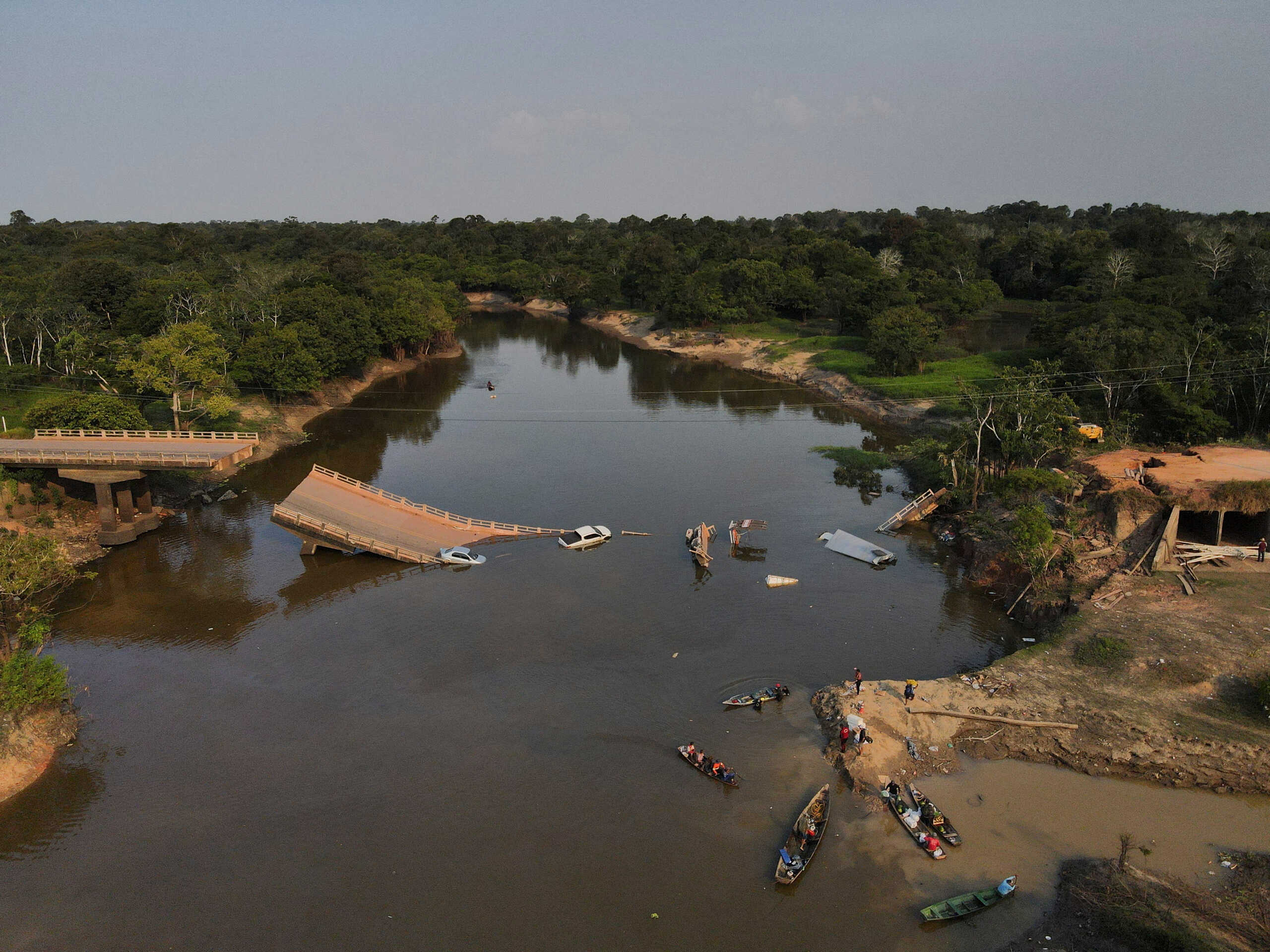 Locals and rescue workers navigate on boats at Curuca river after a bridge collapsed in BR-319 road in Careiro da Varzea, near Manaus, Brazil, September 28, 2022. REUTERS