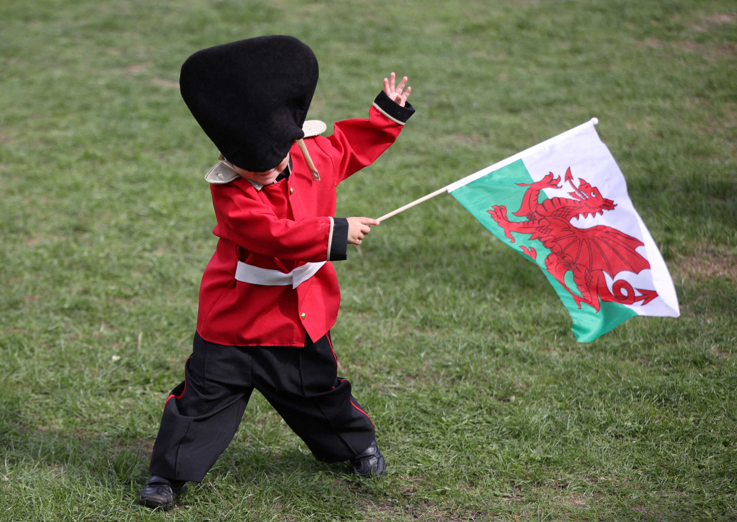 A child waves a Welsh flag ahead of Britain's King Charles' arrival at Cardiff Castle, following the death of Britain's Queen Elizabeth, in Cardiff, Wales, Britain, September 16, 2022.REUTERS