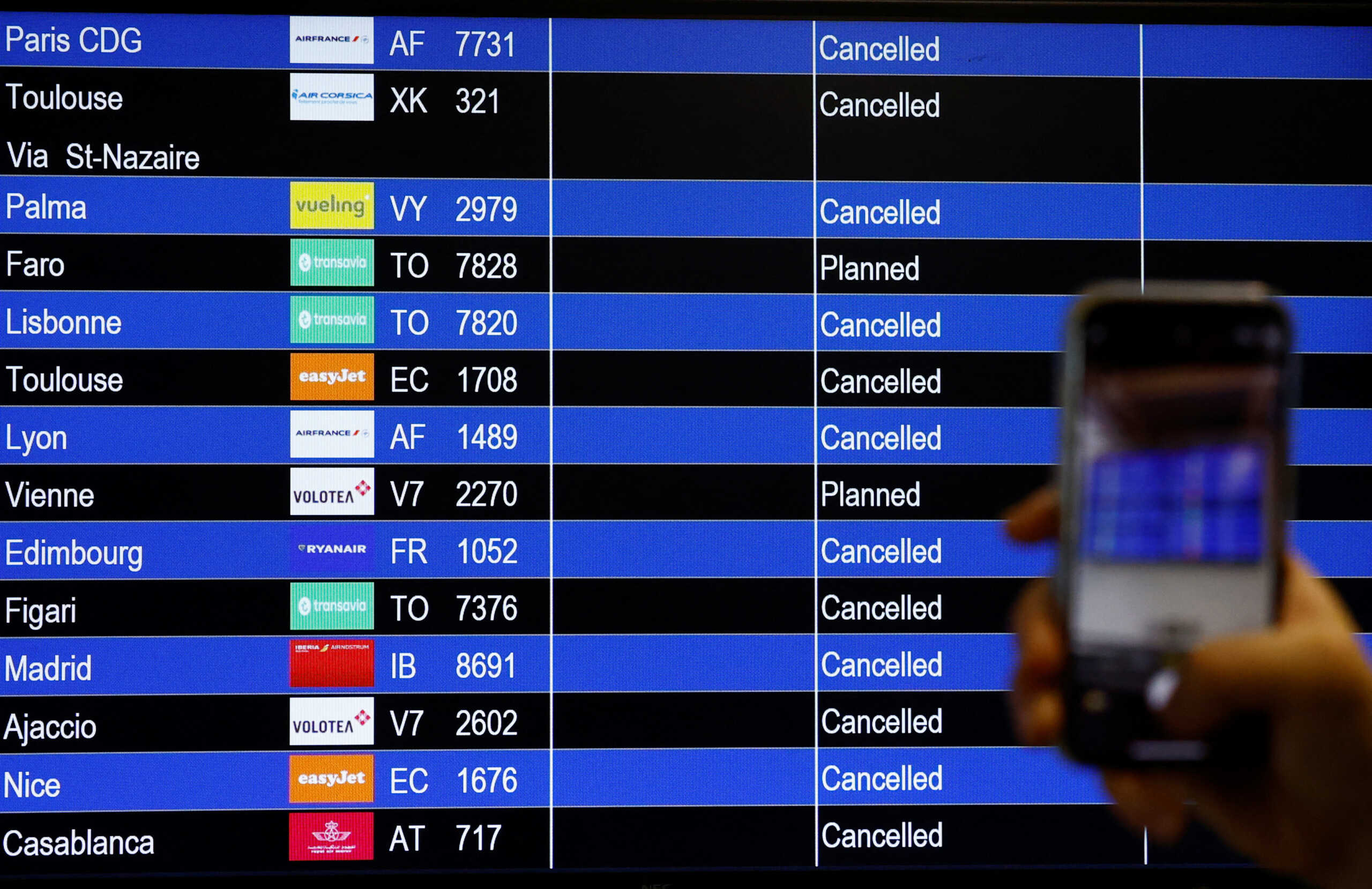 A traveller takes a picture of a flight departure screen displaying a series of flight cancellations during an air traffic controller's strike at the Nantes Atlantique airport in Bouguenais near Nantes, France, September 16, 2022. REUTERS