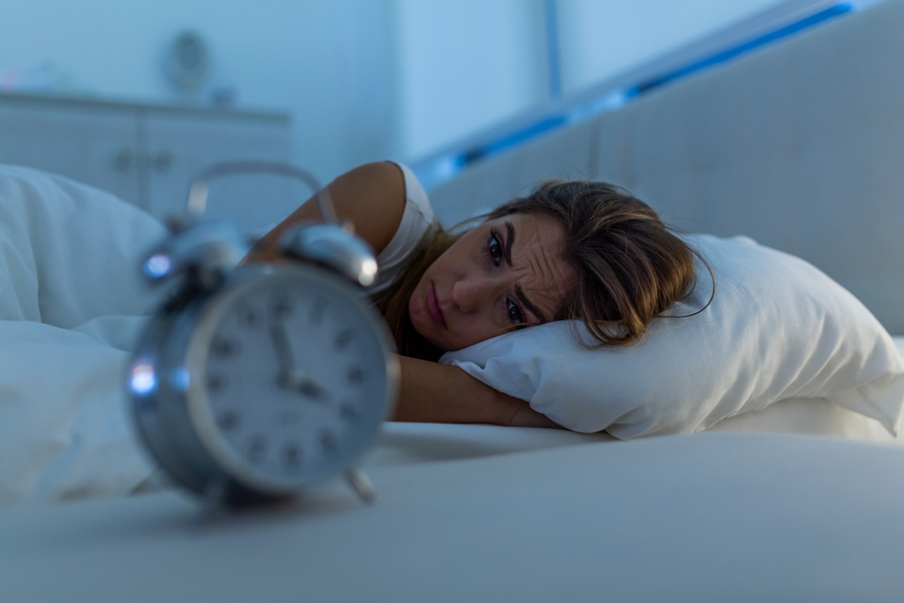 Woman with insomnia lying in bed with open eyes. Girl in bed suffering insomnia and sleep disorder thinking about his problem at night