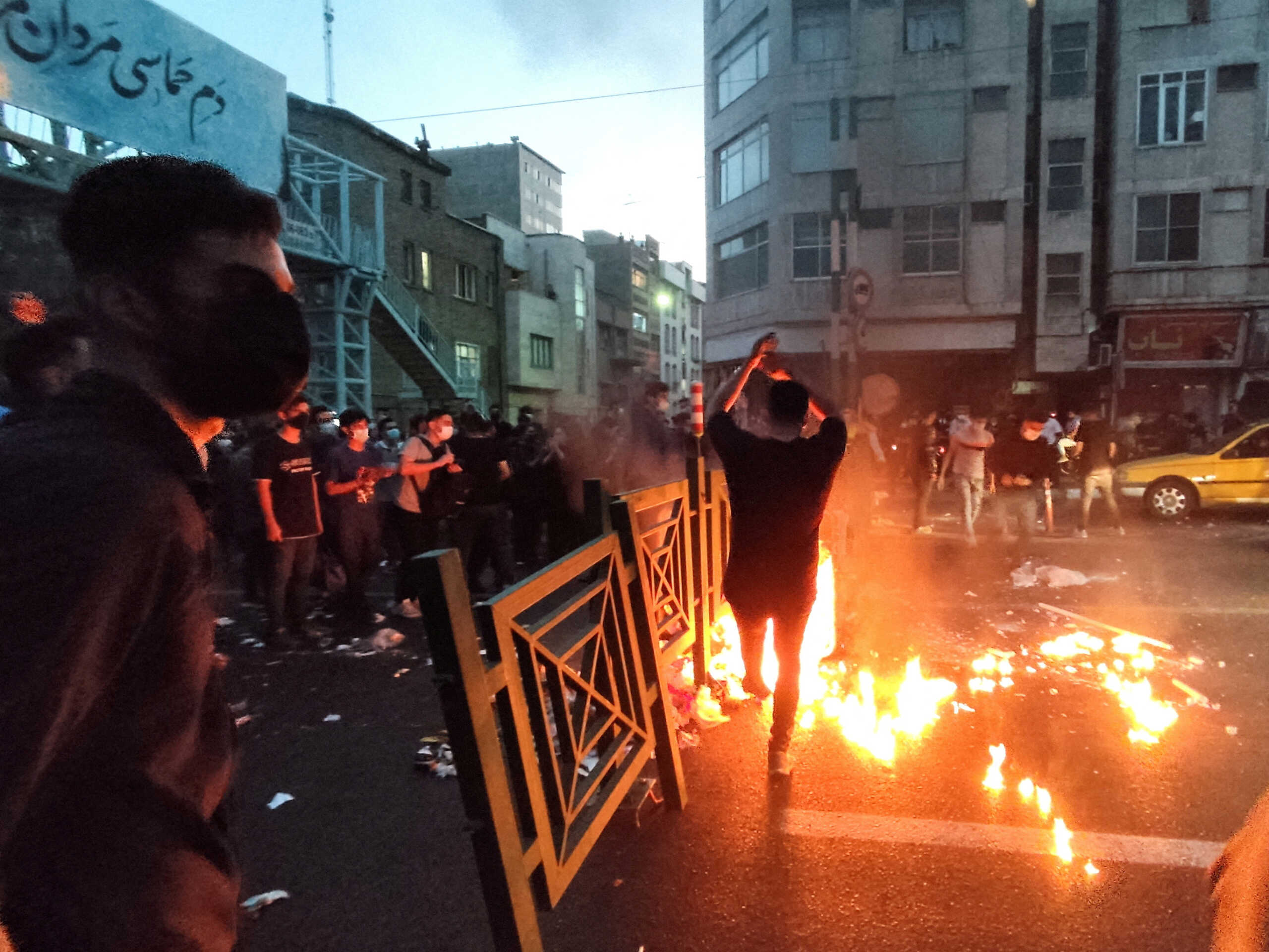 FILE PHOTO: People light a fire during a protest over the death of Mahsa Amini, a woman who died after being arrested by the Islamic republic's "morality police", in Tehran, Iran September 21, 2022. WANA (West Asia News Agency) via REUTERS ATTENTION EDITORS - THIS IMAGE HAS BEEN SUPPLIED BY A THIRD PARTY. BEST QUALITY AVAILABLE DUE TO LIGHTING CONDITIONS