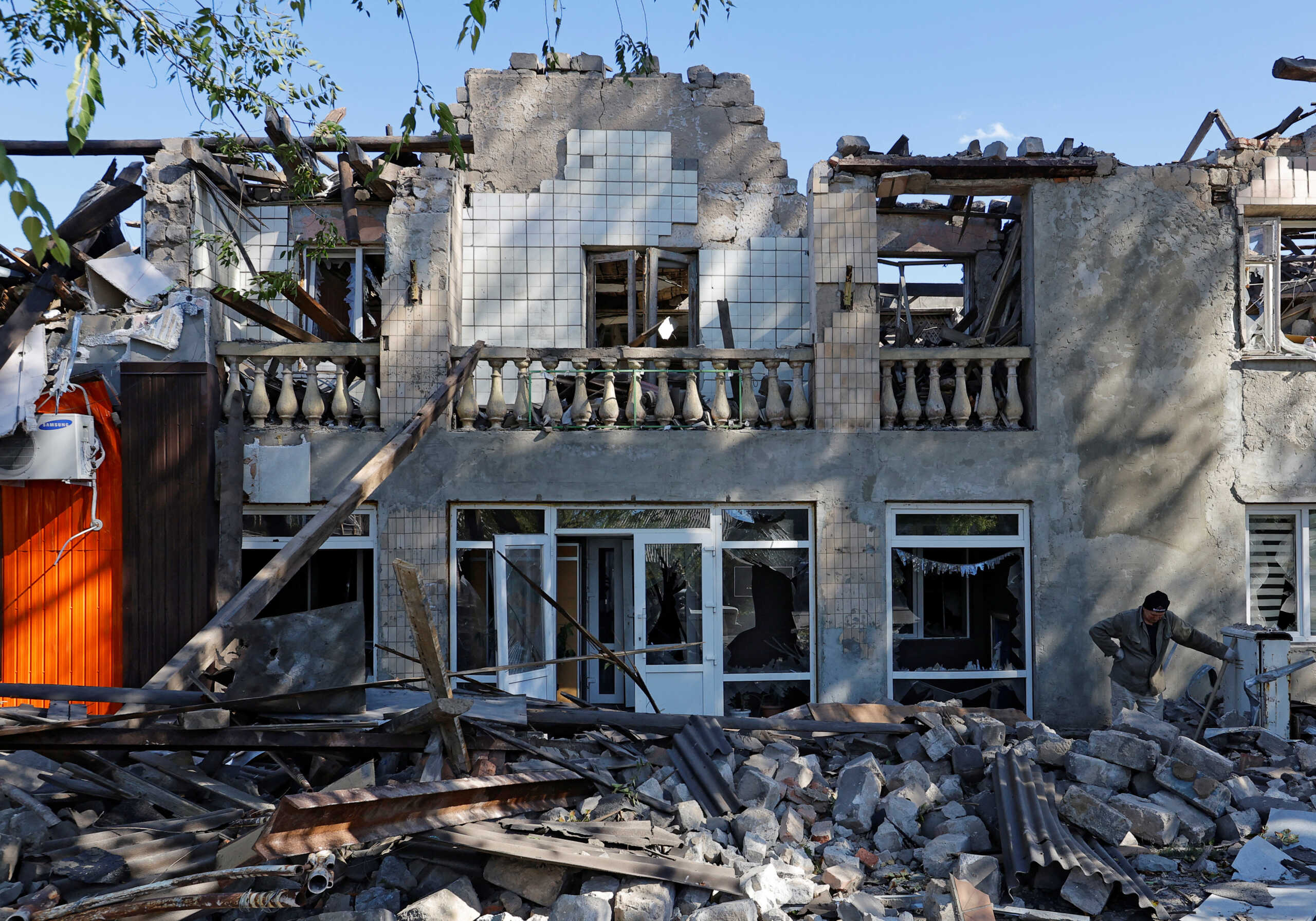 A man removes debris of a building destroyed by recent shelling during Russia-Ukraine conflict in the city of Kadiivka (Stakhanov) in the Luhansk region, Ukraine September 19, 2022. REUTERS