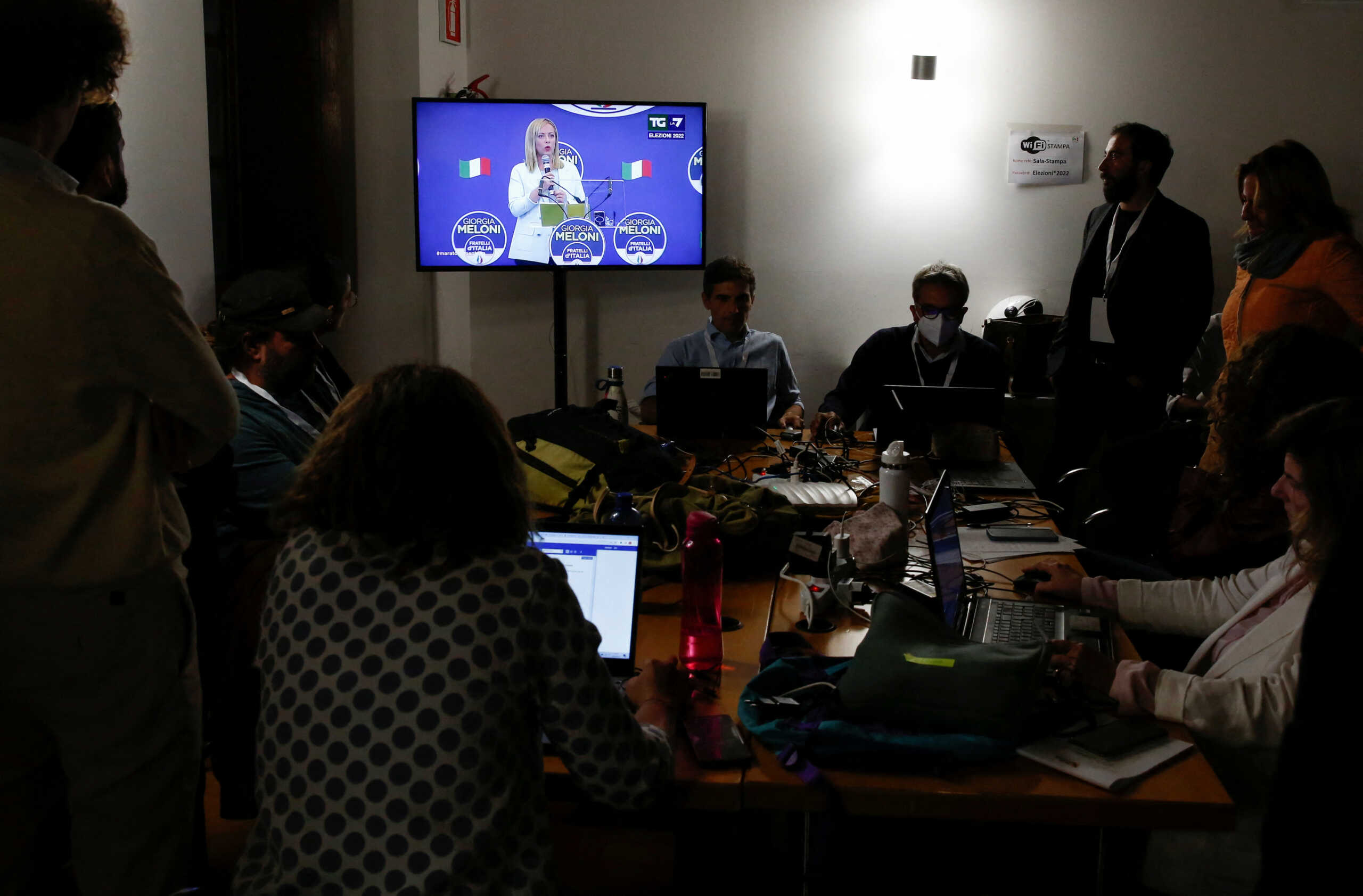 Members of the media look at a television screen with Leader of Brothers of Italy Giorgia Meloni speaking, at the Democratic Party's election night headquarters, in Rome, Italy September 26, 2022. REUTERS