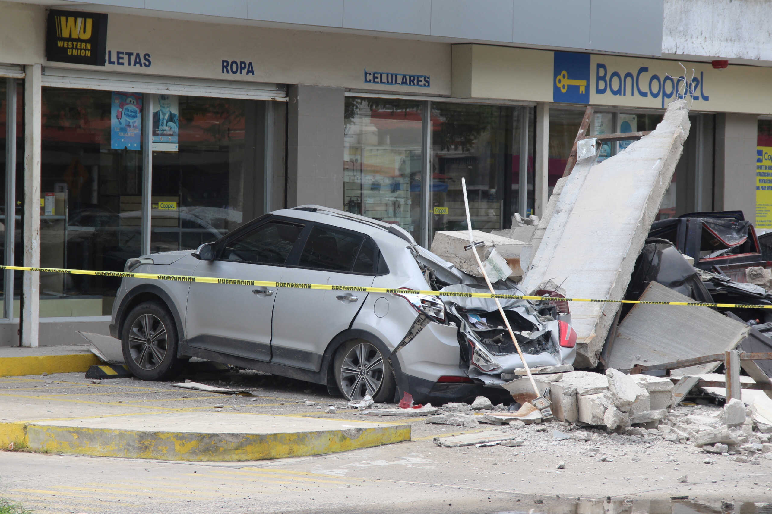 Vehicles damaged by the collapse of the facade of a department store during an earthquake are pictured in Manzanillo, Mexico September 19, 2022. REUTERS