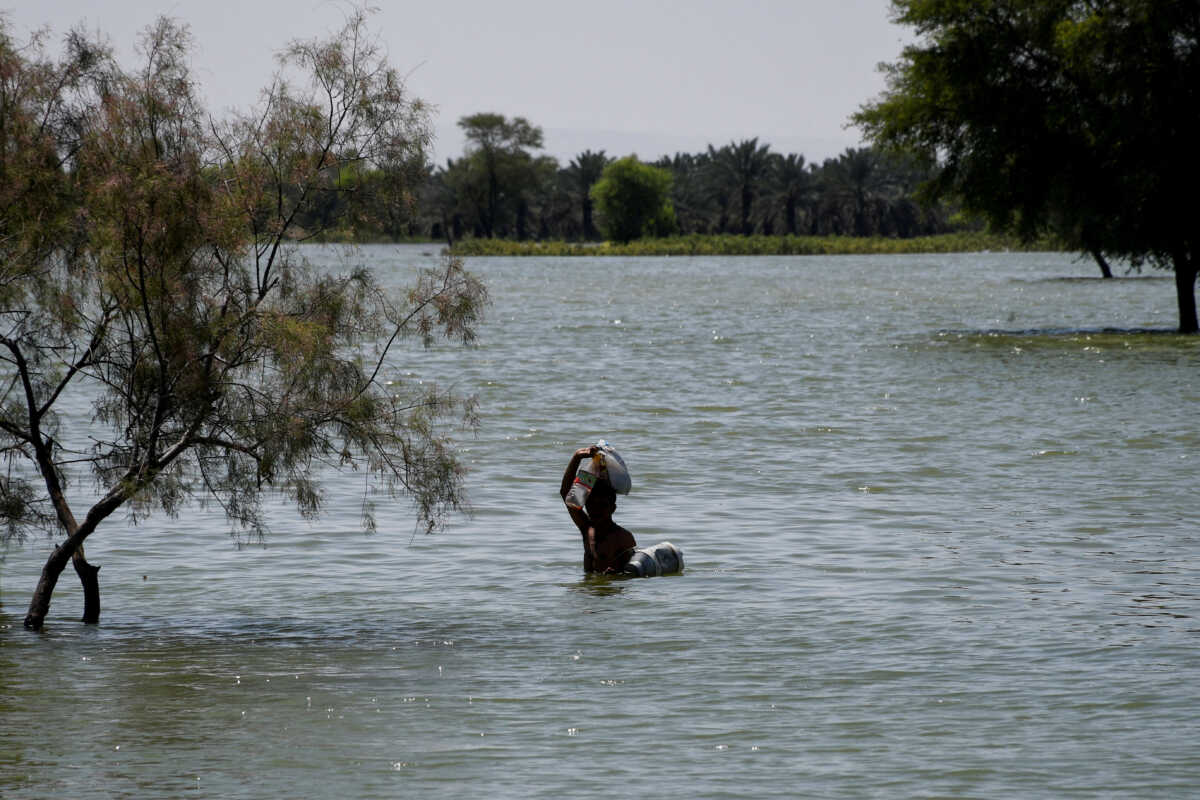 A flood victim wades through floodwater, following rains and floods during the monsoon season in Bajara village, Sehwan, Pakistan, August 31, 2022. REUTERS
