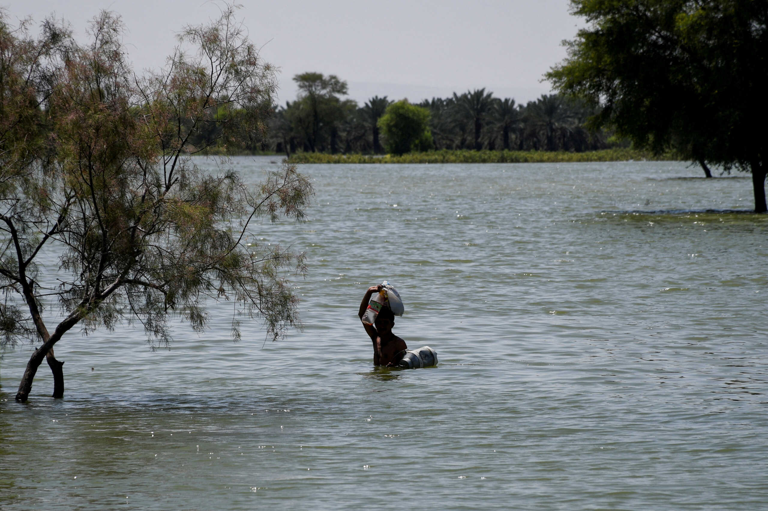 A flood victim wades through floodwater, following rains and floods during the monsoon season in Bajara village, Sehwan, Pakistan, August 31, 2022. REUTERS