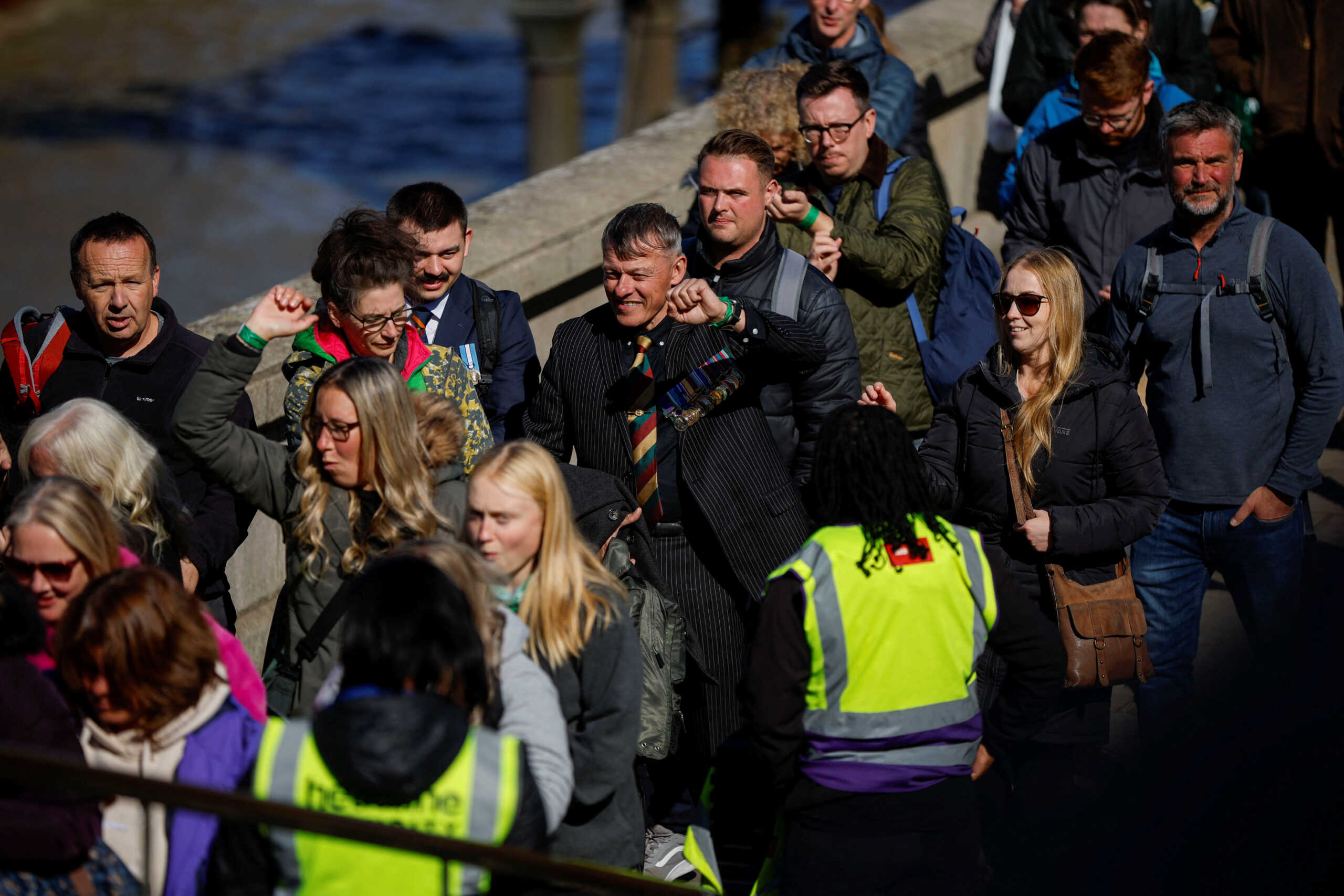 People show their wristbands to security staff as they queue to pay their respects to Britain's Queen Elizabeth following her death, in London, Britain, September 17, 2022.  REUTERS