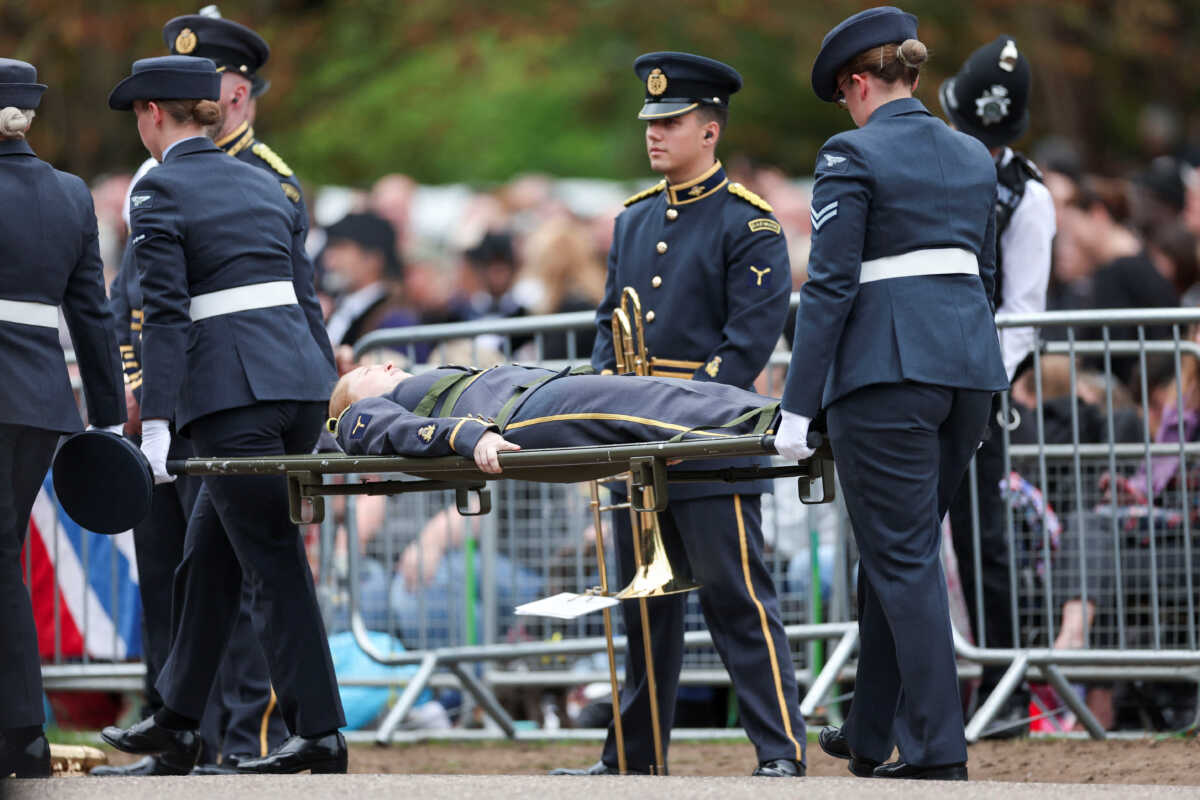 A member of the music band receives assistance on the day of state funeral and burial of Britain's Queen Elizabeth, in Windsor, Britain, September 19, 2022. REUTERS