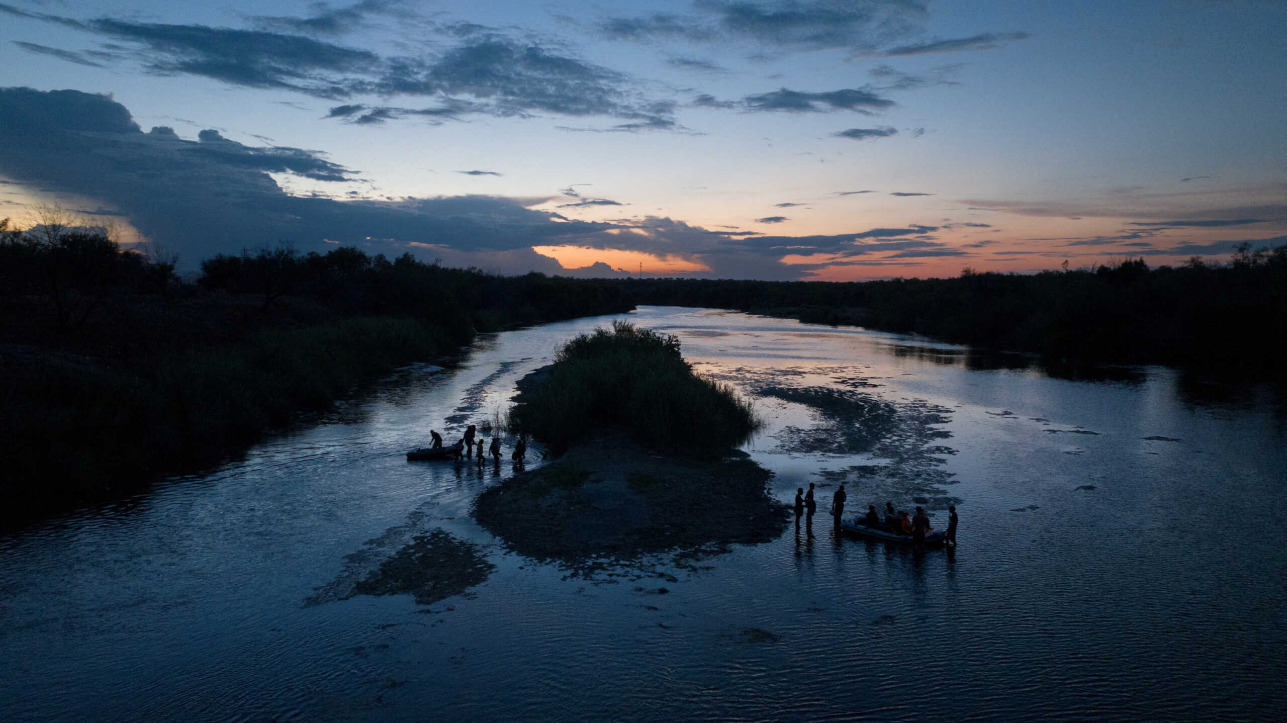 Smugglers transport asylum seeking migrants to a sandbar in the midst of the Rio Grande river before entering the United States from Ciudad Miguel Aleman, Mexico August 26, 2022. REUTERS