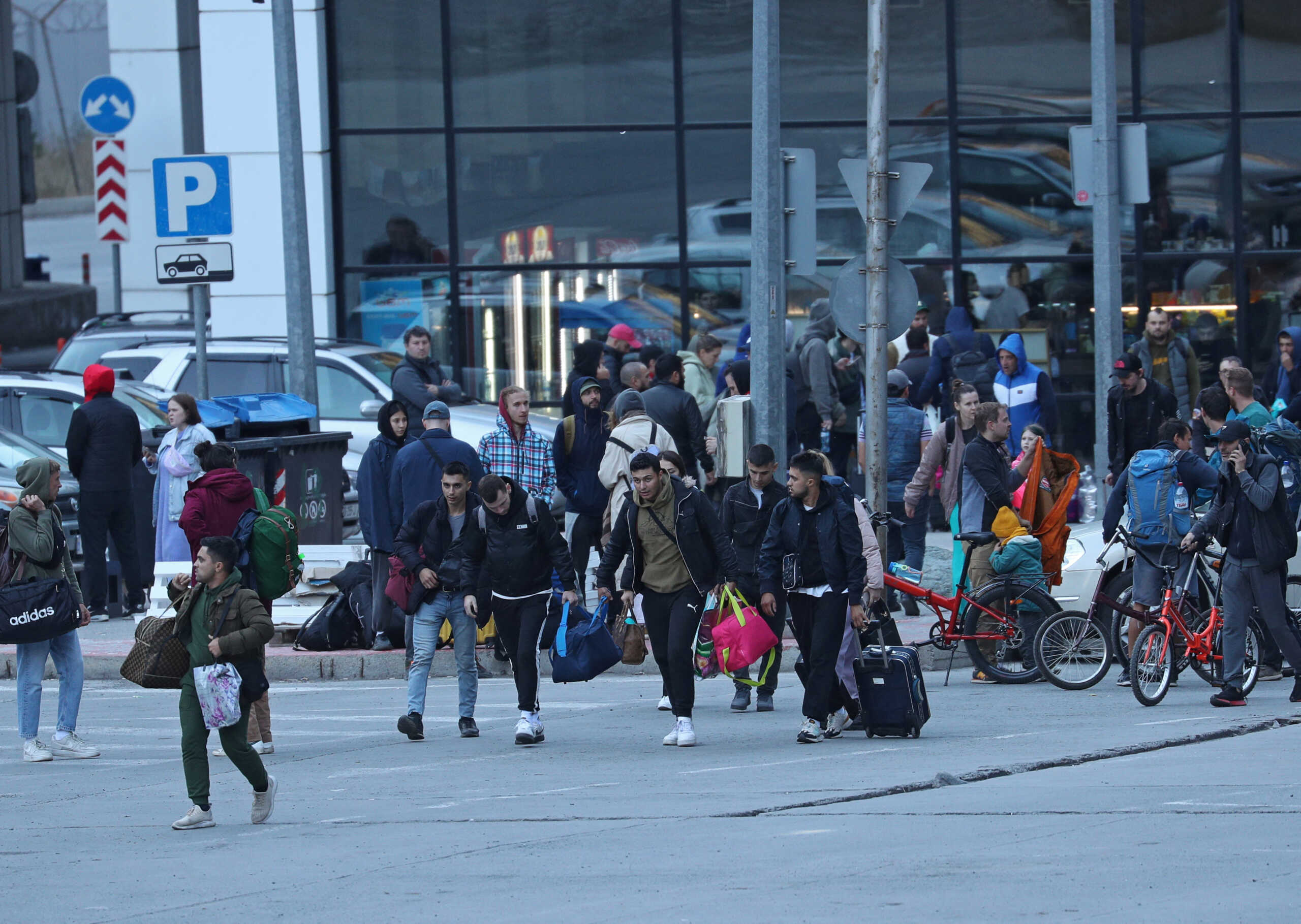 Travellers from Russia cross the border to Georgia at the Zemo Larsi