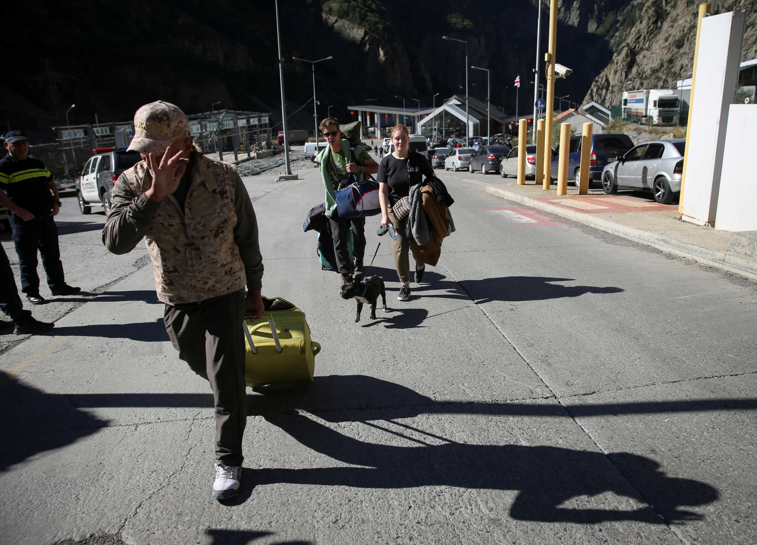 Travellers from Russia cross the border to Georgia at the Zemo Larsi