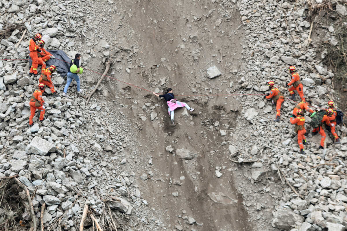 Rescue workers evacuate quake-affected residents at the site of a landslide near Moxi town, following a 6.8-magnitude earthquake in Luding county, Ganzi Tibetan Autonomous Prefecture, Sichuan province, China September 6, 2022. China Daily via REUTERS  ATTENTION EDITORS - THIS IMAGE WAS PROVIDED BY A THIRD PARTY. CHINA OUT.