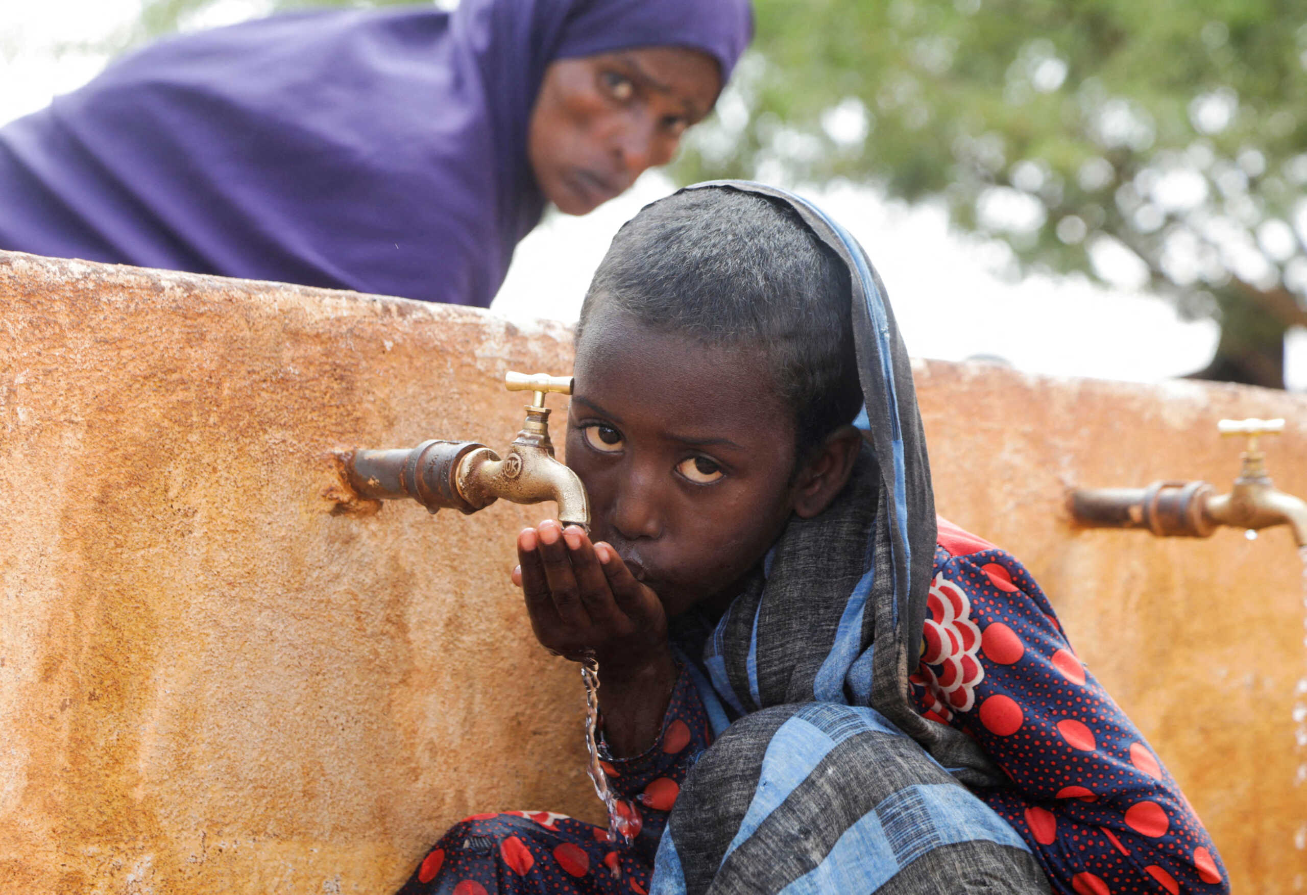 FILE PHOTO: Somali displaced girl Sadia Ali, 8, drinks water from a tap at the Kaxareey  camp for the internally displaced people in Dollow, Gedo region of Somalia May 24, 2022. Picture taken May 24, 2022. REUTERS