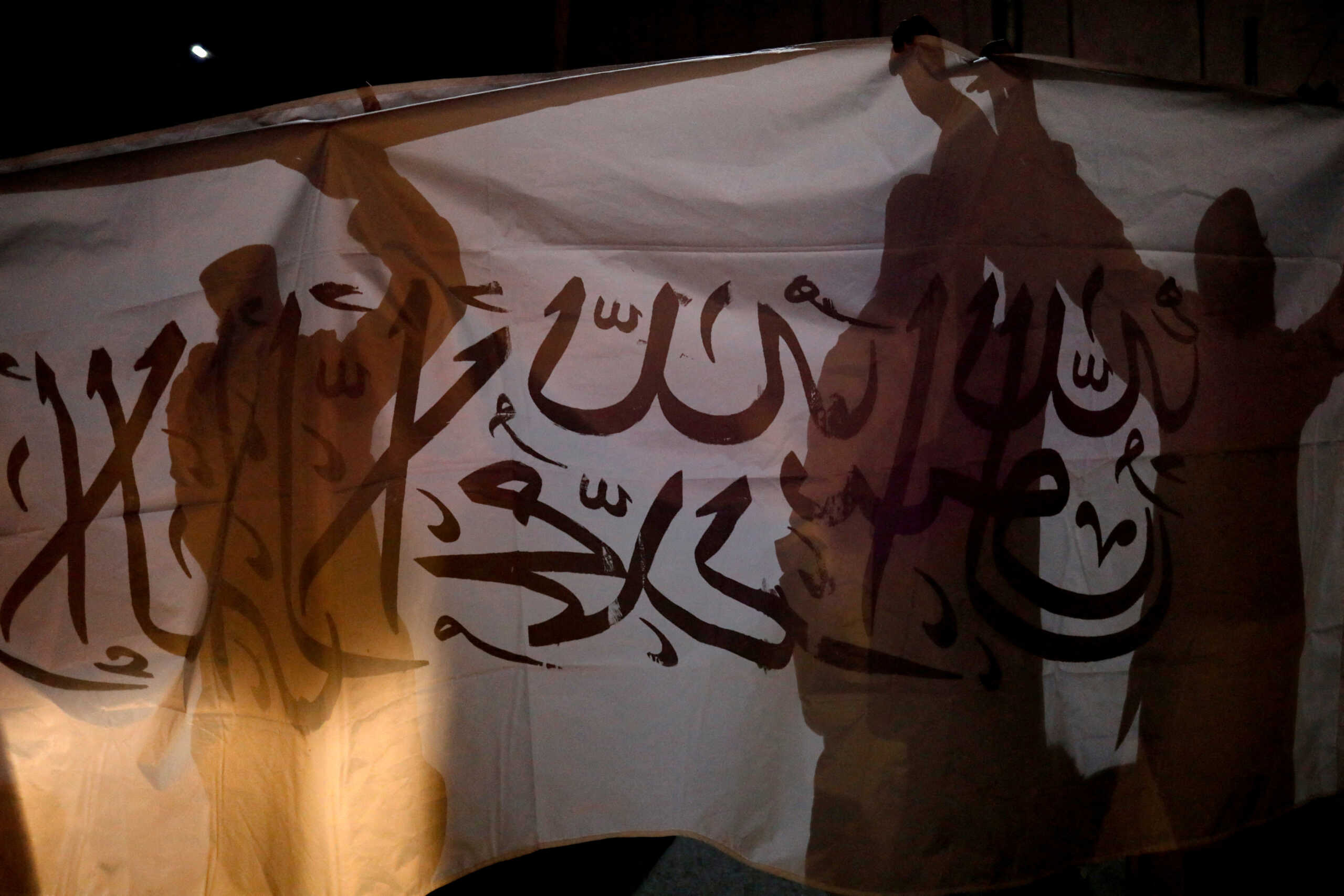 Taliban supporters hold an Islamic Emirate of Afghanistan flag on the first anniversary of the departure of U.S. forces from the country, on a street in Kabul, Afghanistan, August 30, 2022. REUTERS