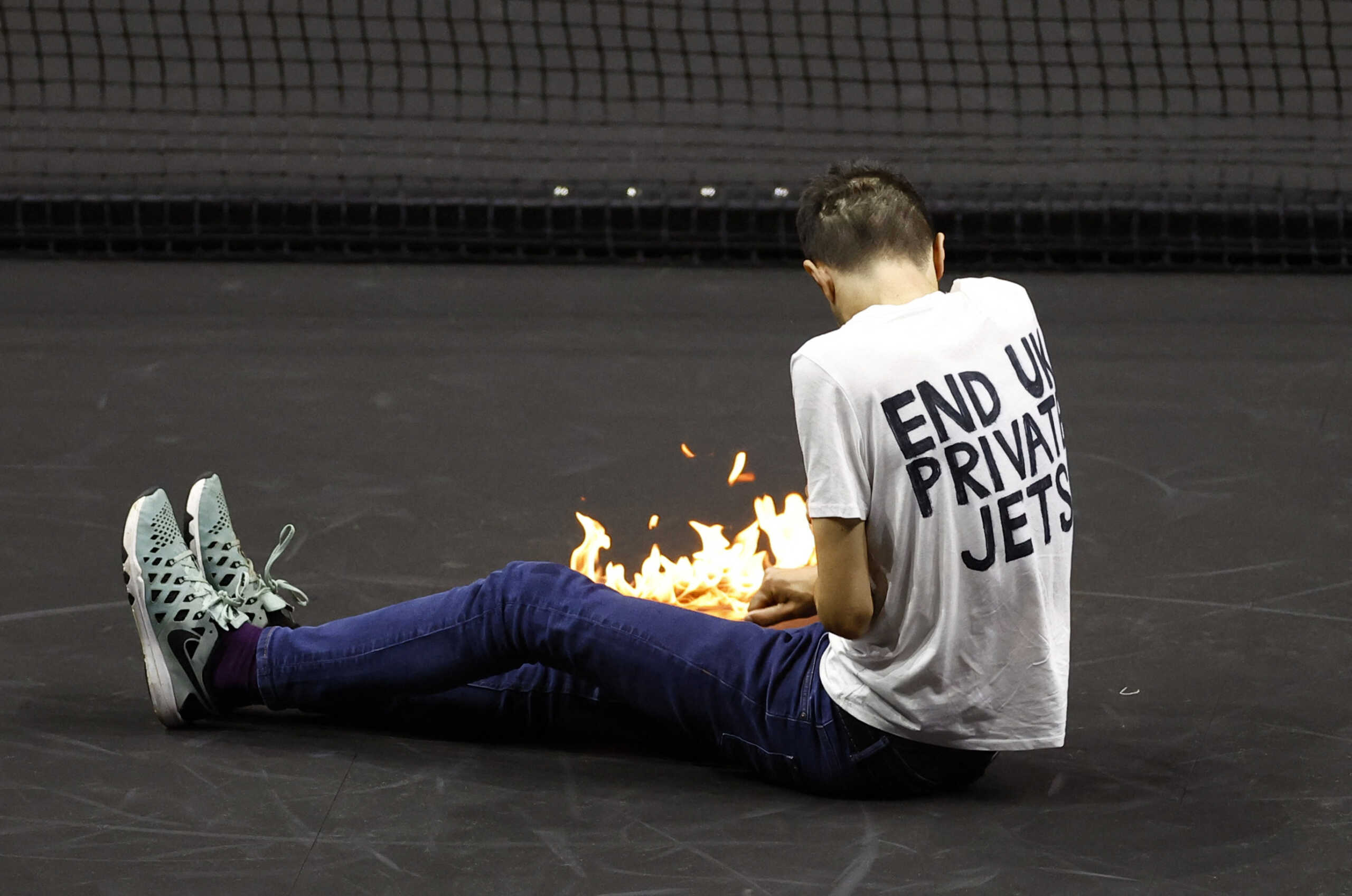 Tennis - Laver Cup - 02 Arena, London, Britain - September 23, 2022   A protester lights a fire on the court during the match between Team Europe's Stefanos Tsitsipas and Team World's Diego Schwartzman Action Images via Reuters