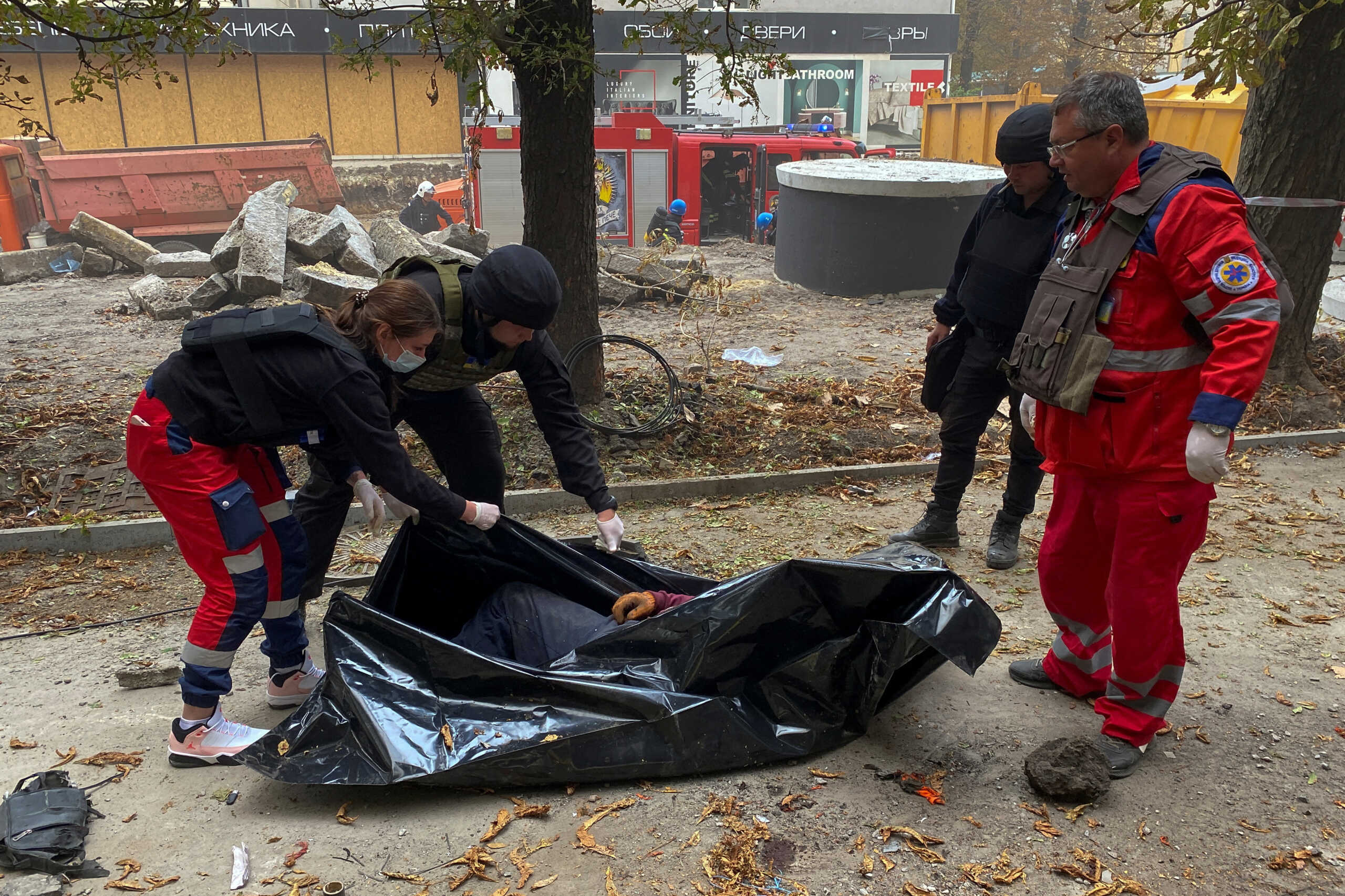 SENSITIVE MATERIAL. THIS IMAGE MAY OFFEND OR DISTURB A paramedic and a police officer close the bag with the body of a man killed during a Russian military strike, amid Russia's attack on Ukraine, in Kharkiv, Ukraine September 12, 2022.  REUTERS