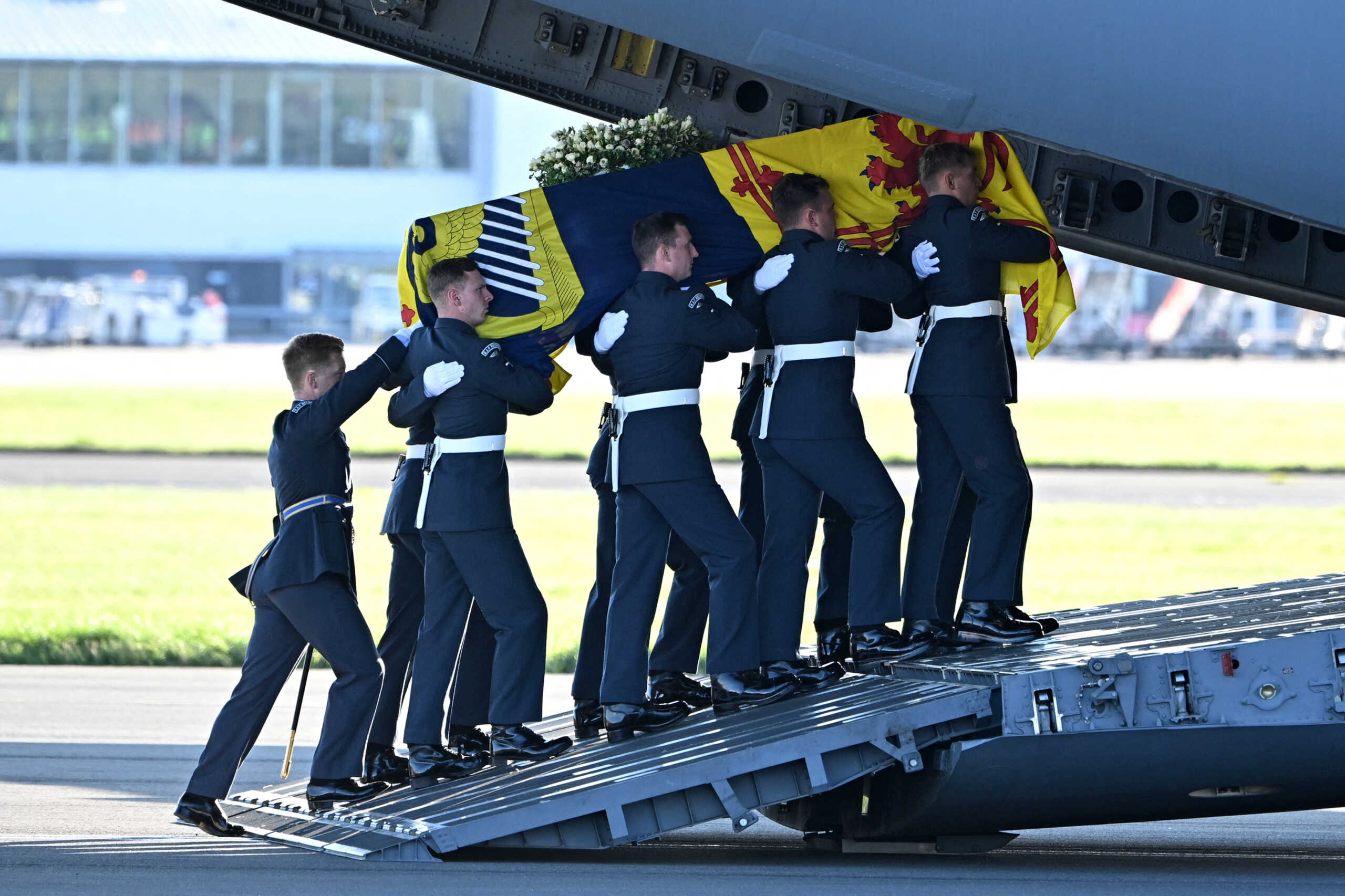 Pallbearers from the Queen's Colour Squadron of the Royal Air Force (RAF) carry the coffin of Queen Elizabeth II, draped in the Royal Standard of Scotland, into a RAF C17 aircraft at Edinburgh airport on September 13, 2022, before it is transported to Buckingham Palace in London.      PAUL ELLIS