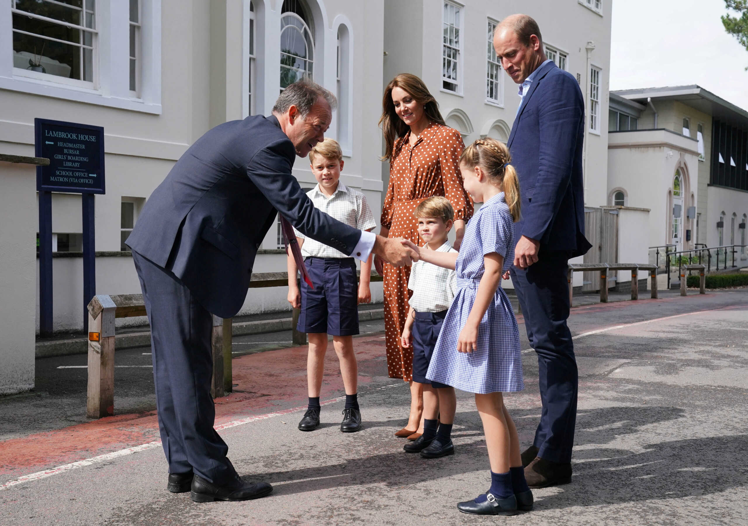 Britain's Prince George, Princess Charlotte and Prince Louis, accompanied by their parents Prince William and Catherine, Duchess of Cambridge, are greeted by Headmaster Jonathan Perry as they arrive for a settling-in afternoon at Lambrook School, an annual event held to welcome new starters and their families the day before the start of the new school term, near Ascot in Berkshire, Britain, September 7, 2022. Jonathan Brady