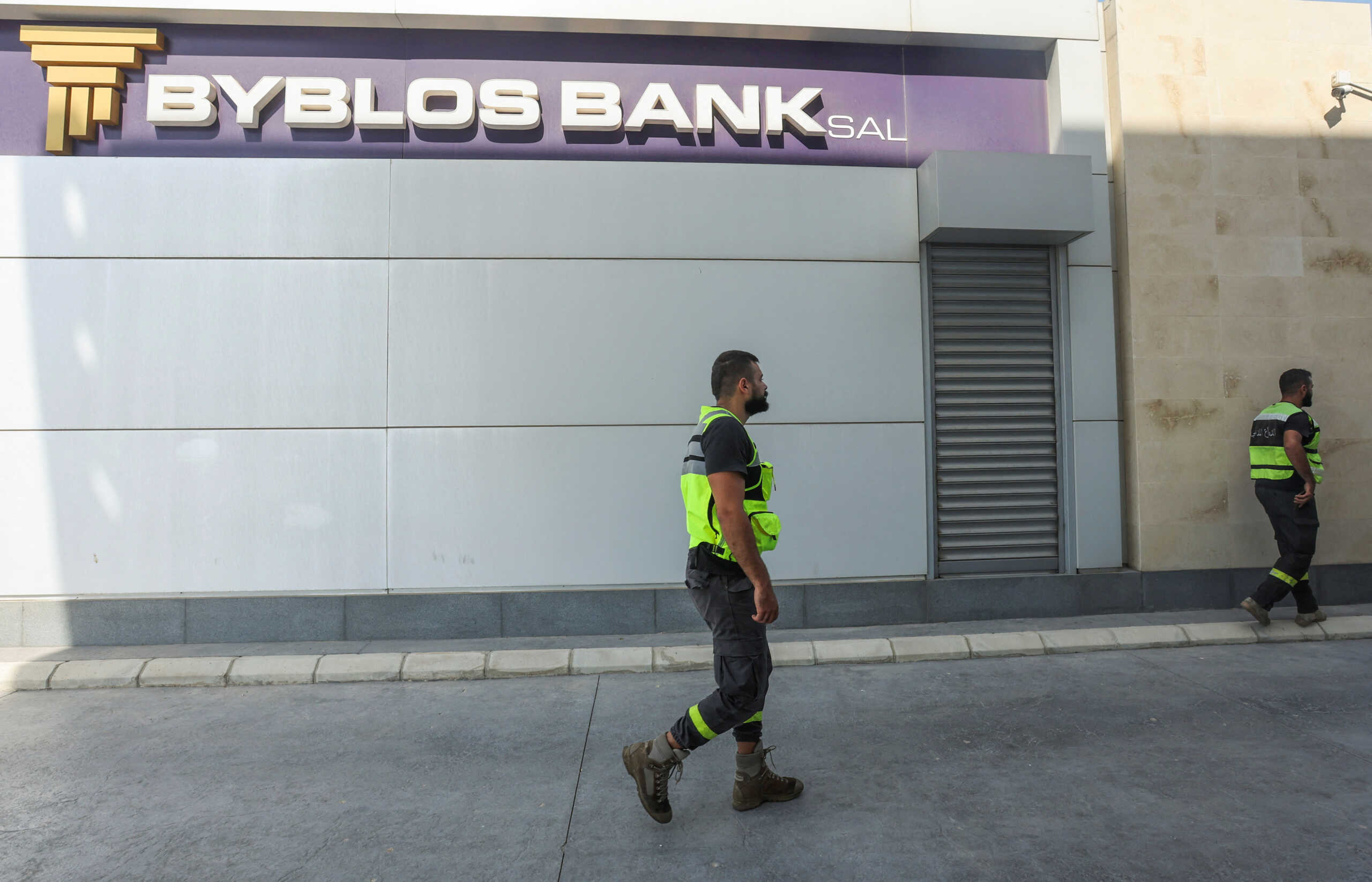 Members of the civil defence walk outside a Byblos Bank branch where an armed depositor took hostages according to the Depositors' Association, in Tyre Lebanon October 4, 2022. REUTERS