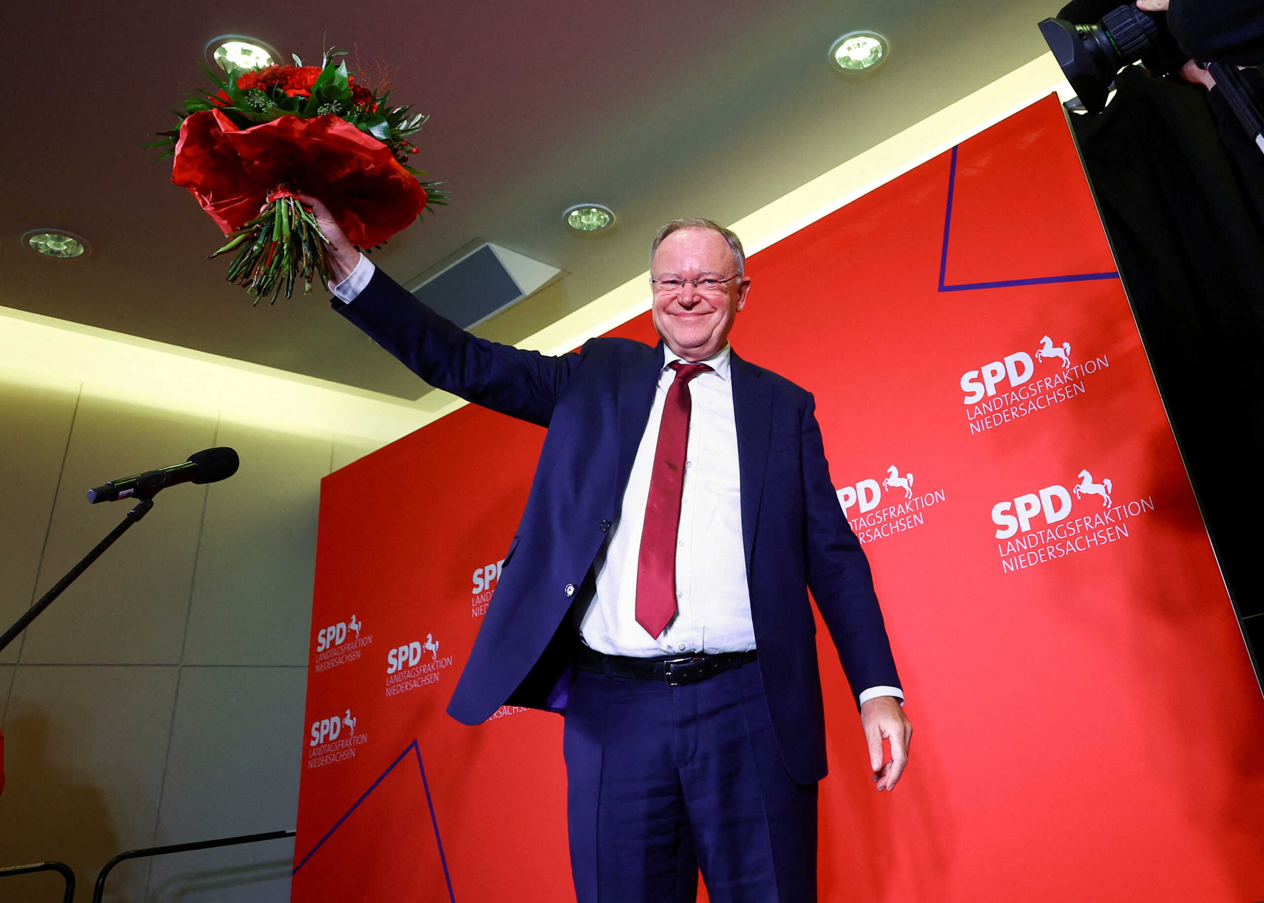 Stephan Weil, incumbent Social Democratic Party (SPD) federal state Premier of Lower Saxony reacts on stage with a bunch of flowers after first election polls showed his party in the lead following the Lower Saxony elections in Hanover, Germany, October 9, 2022.  REUTERS