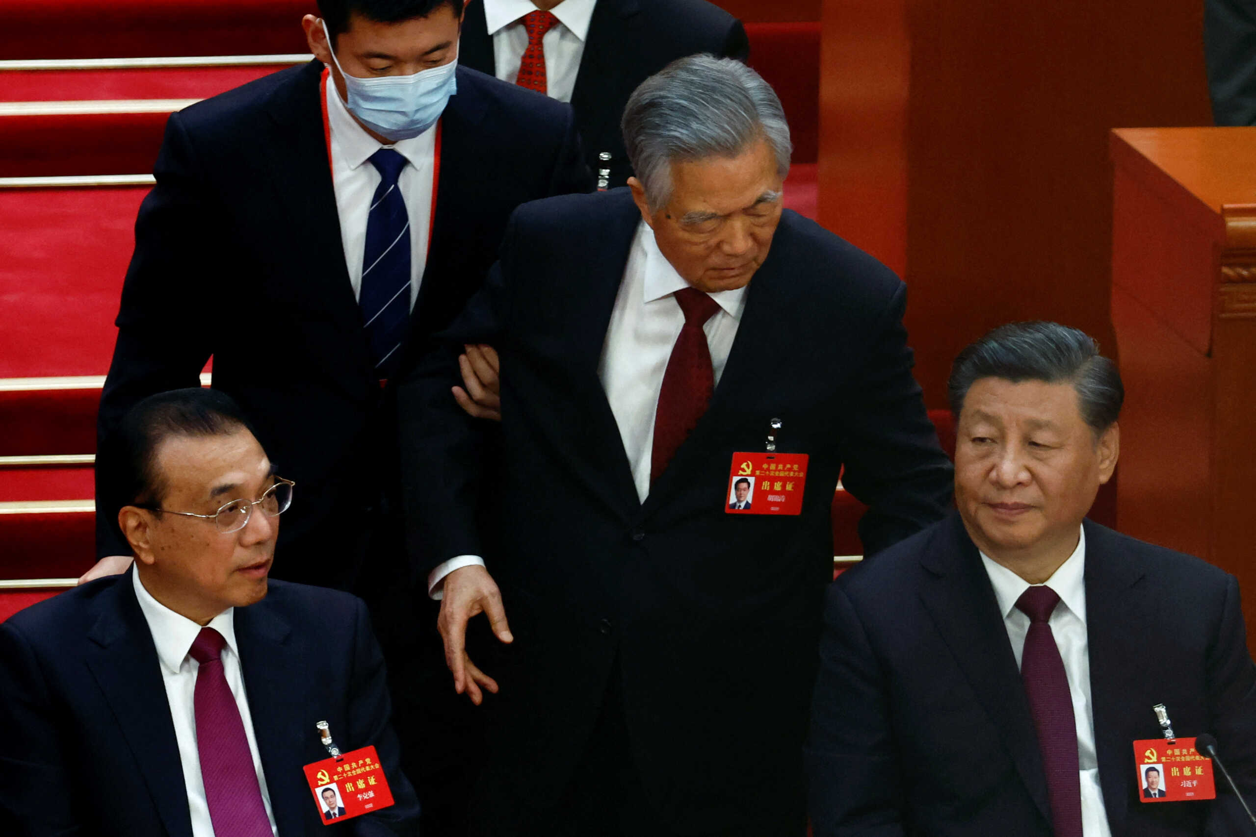 Former Chinese president Hu Jintao leaves his seat next to Chinese President Xi Jinping and Premier Li Keqiang, during the closing ceremony of the 20th National Congress of the Communist Party of China, at the Great Hall of the People in Beijing, China October 22, 2022. REUTERS